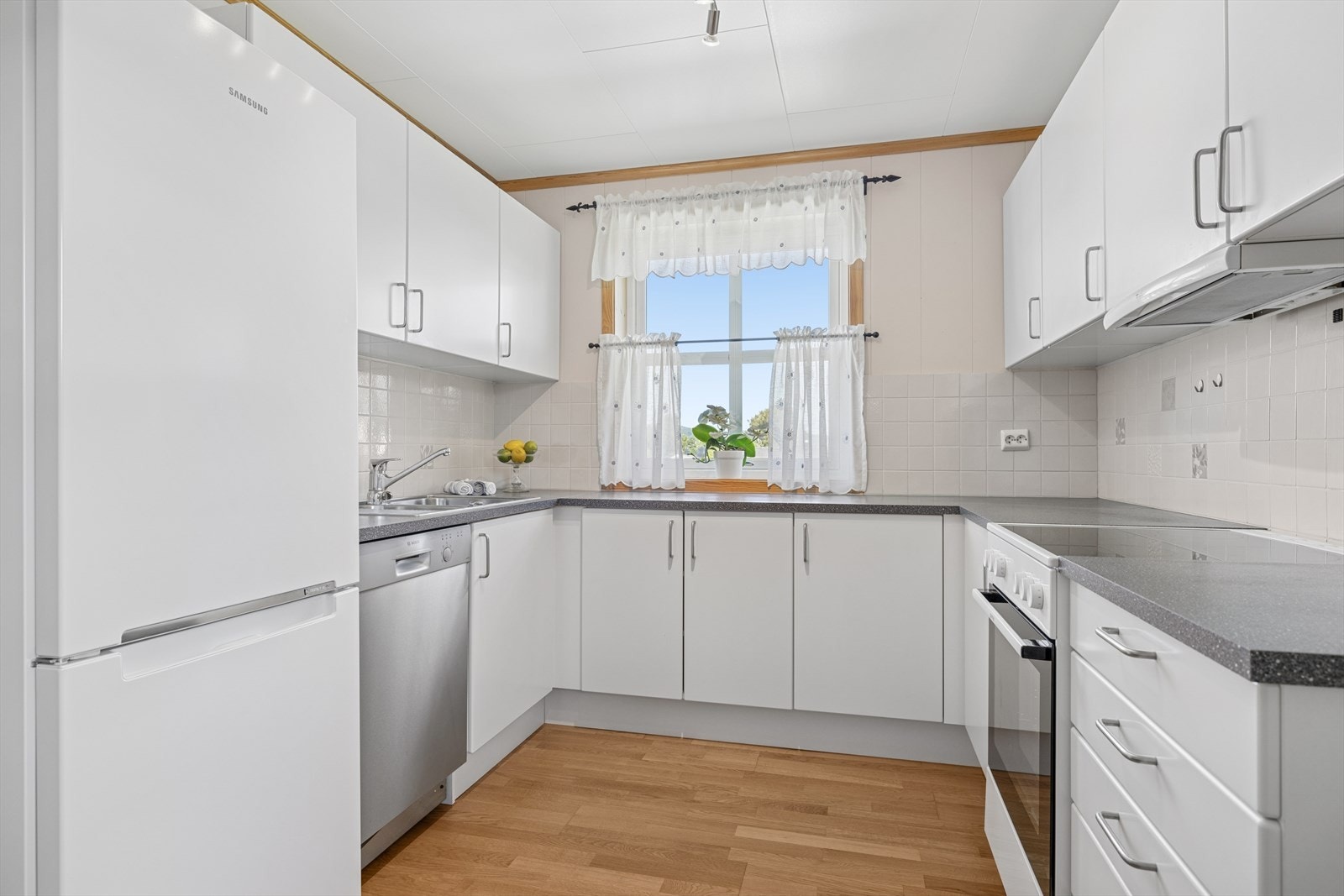 Et lyst og pent kjøkken med god plass til oppbevaring og gode arbeidsforhold. Vinduer slipper inn godt med dagslys og bidrar til en trivelig atmosfære. Galleribilde