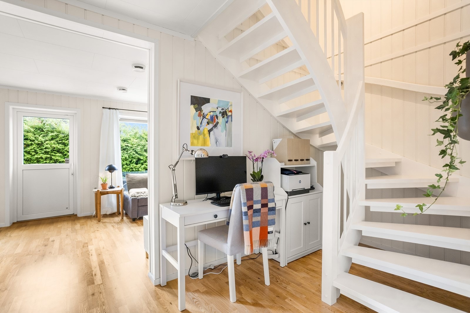 Boligen har en lys og malt tretrapp mellom etasjene. Galleribilde