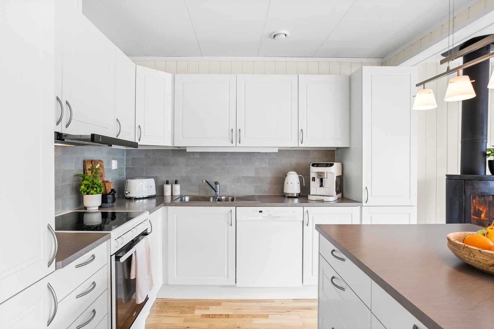 Innredningen består av hvite fronter i profilert utførelse, laminat benkeplate og nedfelt rustfri stålkum. Galleribilde