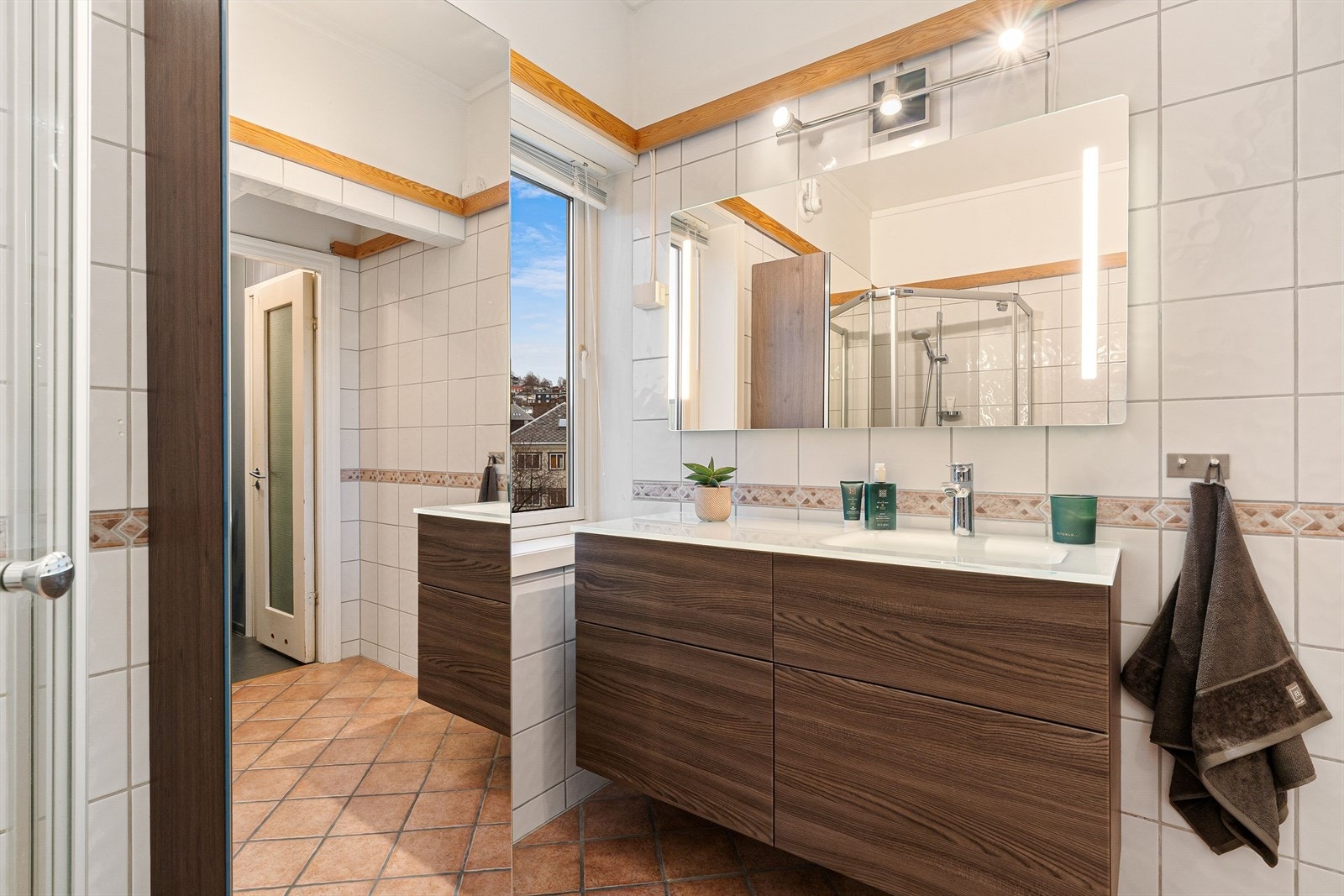 Stor servantinnredning og lysspeil. Badet har elektrisk gulvvarme. Galleribilde