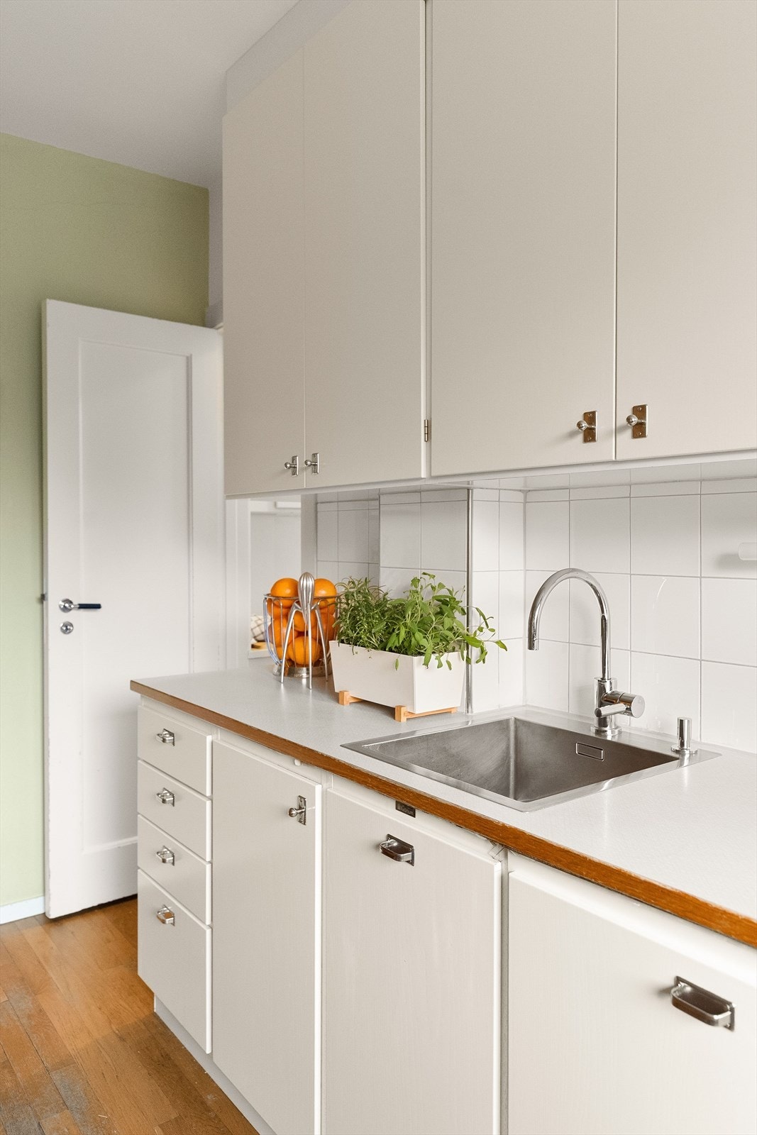 Grep og knotter på kjøkkenet i tidsriktig utførelse og dørhåndtak på originale innerdører tilbakeført til funkisstil i sort bakelitt og krom. Galleribilde