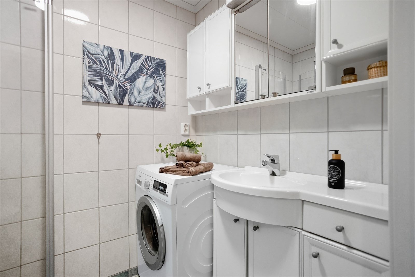 Vegghengt seksjon med praktisk oppbevaringsplass i speilskap, ekstra skap og hyller. Servant med underskap og skuff. (Bak bildet på veggen, er det flislagt en seilskute). Galleribilde