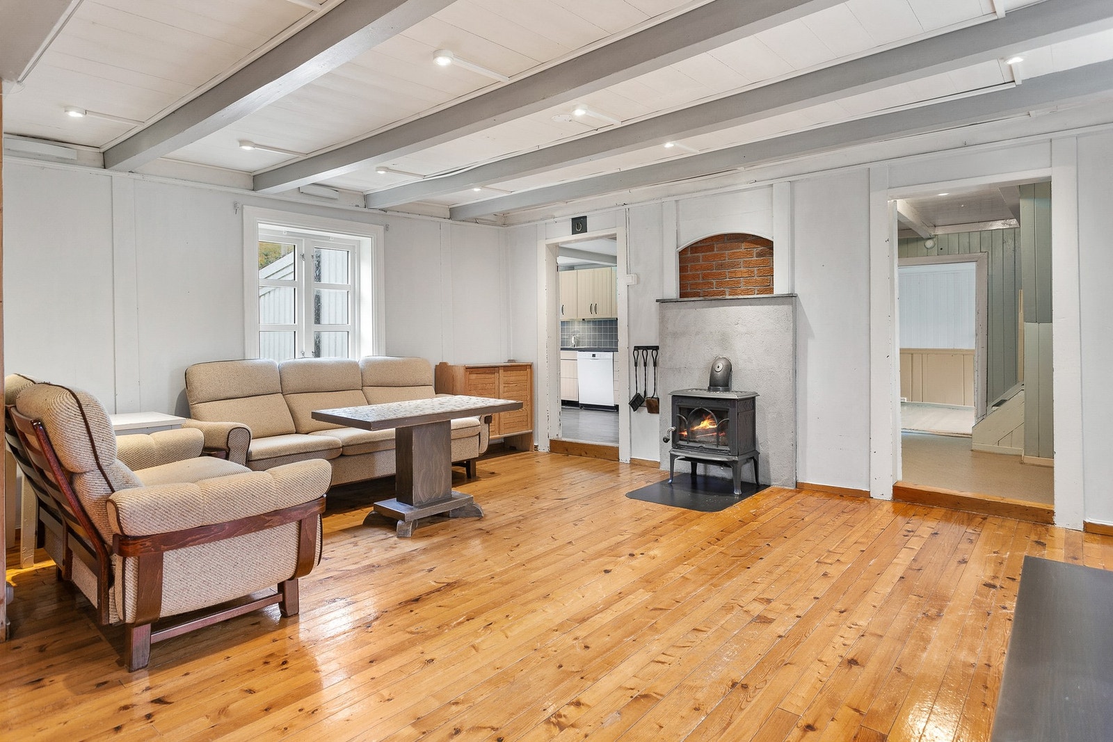 Stuen har vedfyring og spotter i tak . Galleribilde