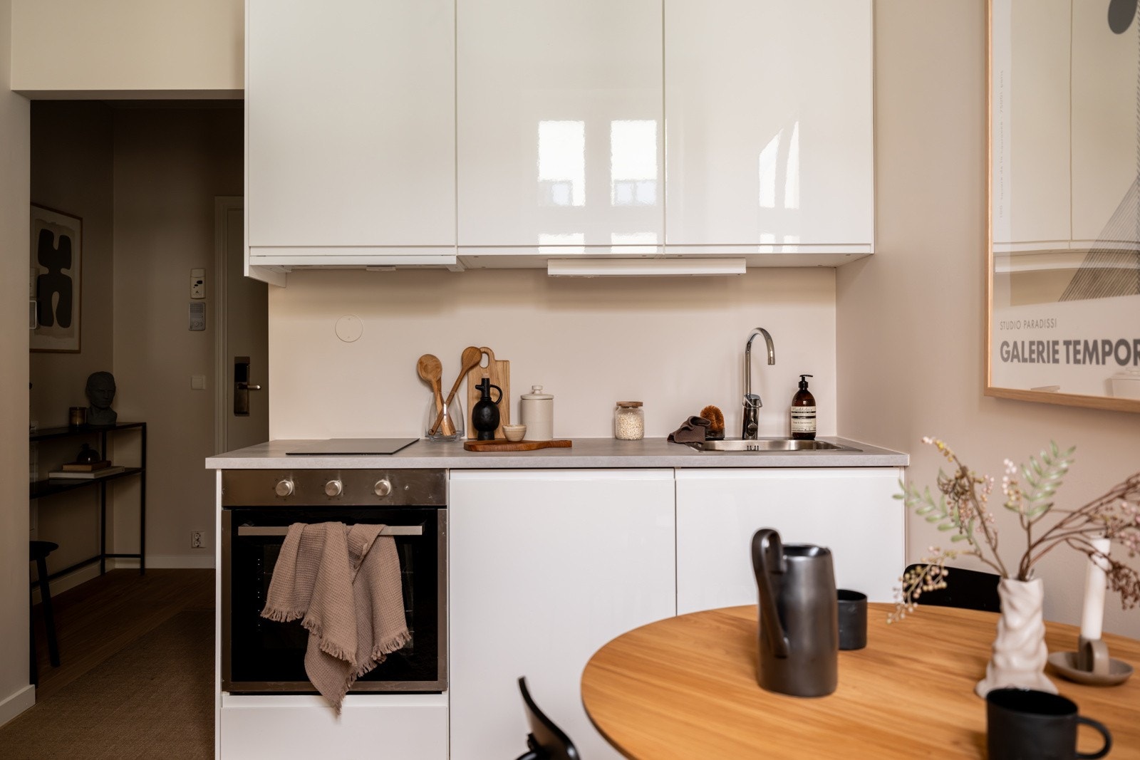 Innredningen har hvite glatte fronter og laminert benkeplate med nedfelt oppvaskkum. Praktisk med belysning under overskap. Galleribilde