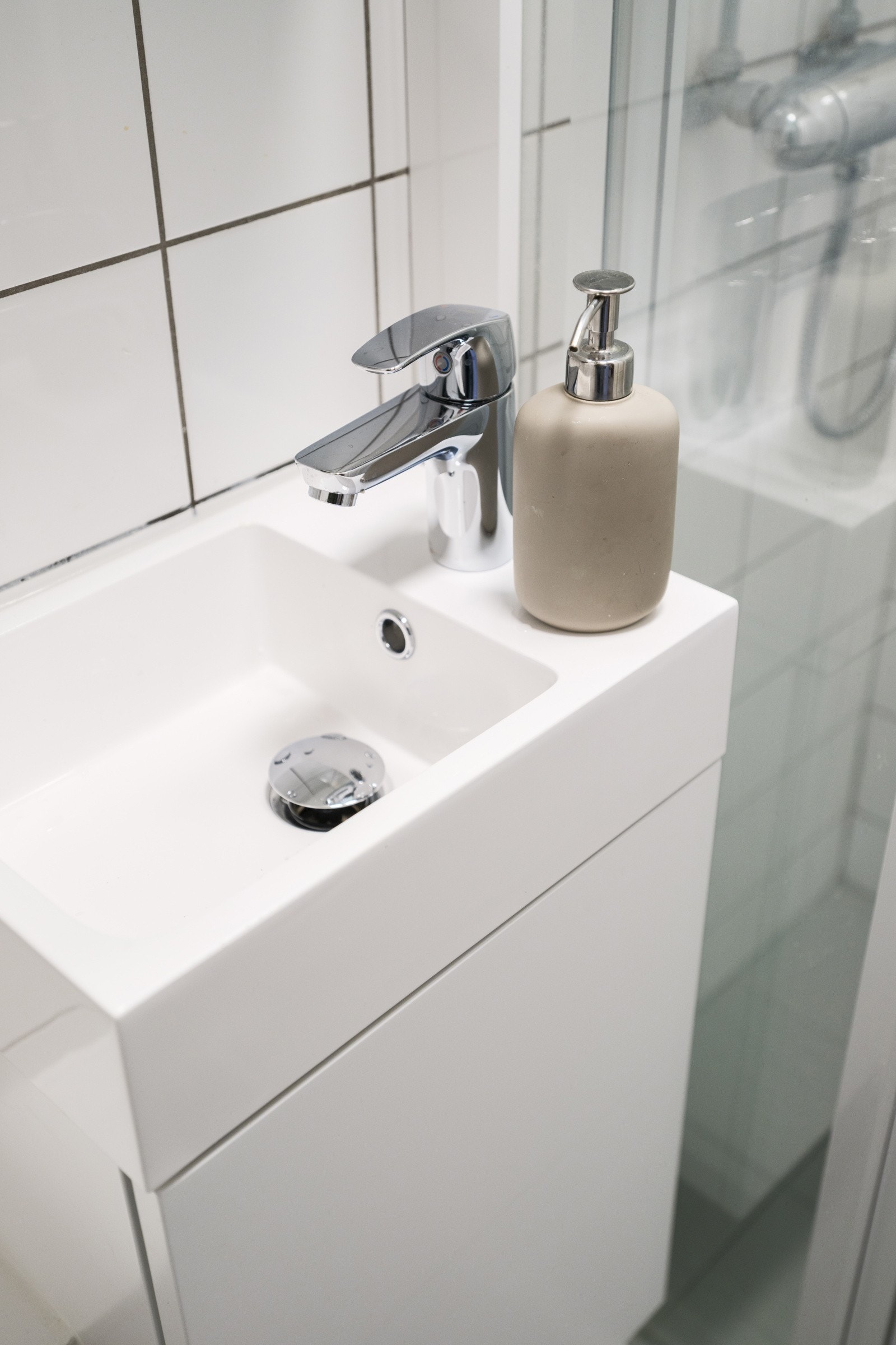 Baderommet er utstyrt med lyst servantskap med speilskap over, dusjnisje med delevegg og vegghengt toalett. Galleribilde