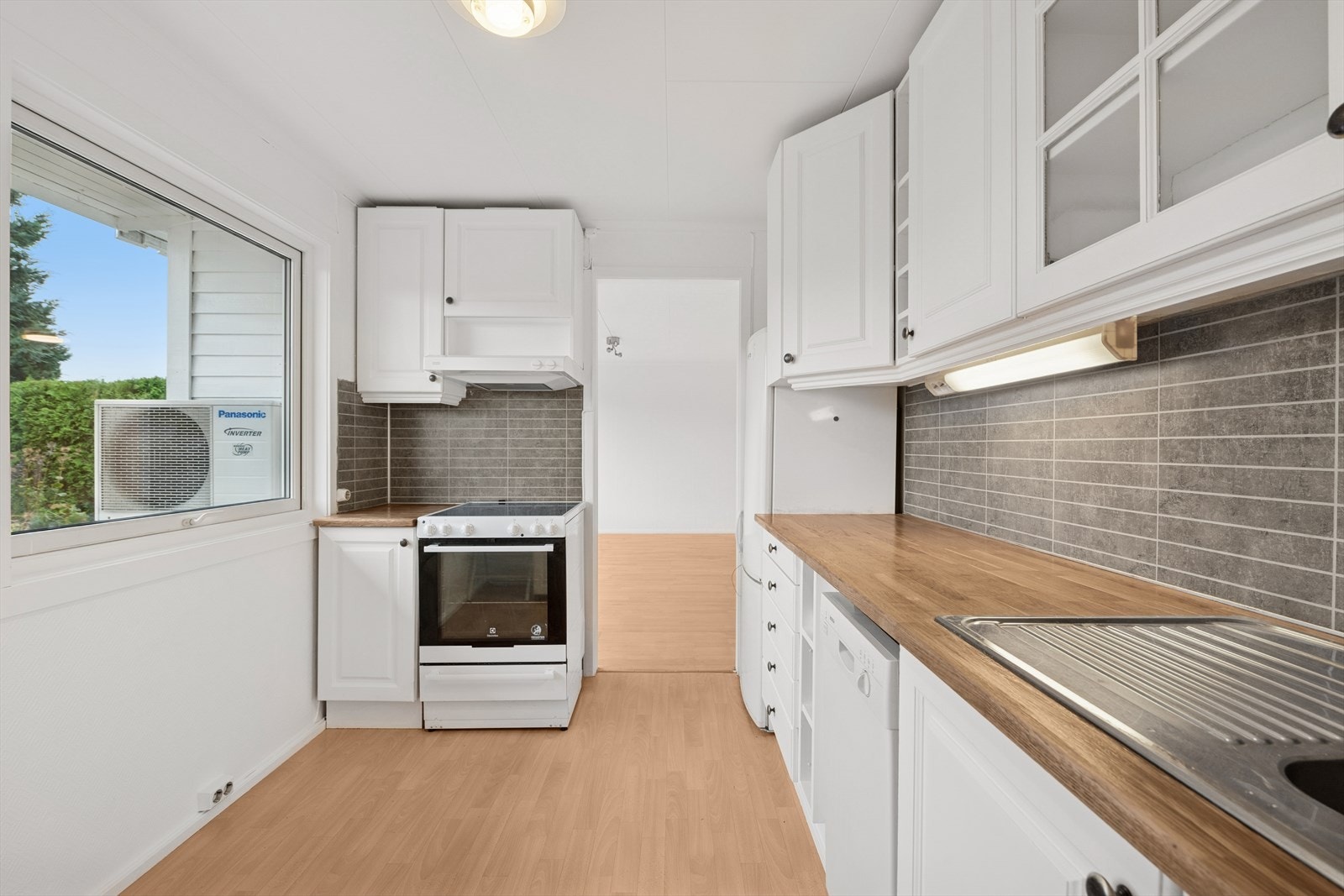 Innredning med profilerte fronter og benkeplaten av heltre, samt røropplegg til oppvaskmaskin Galleribilde