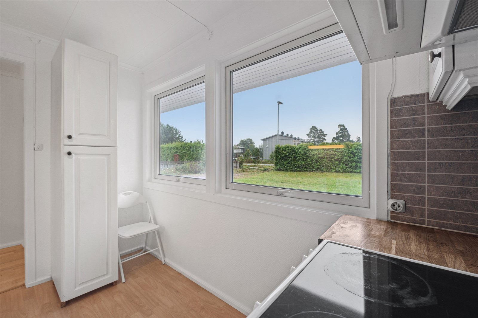 Kjøkken med store vinduer ut mot hage Galleribilde