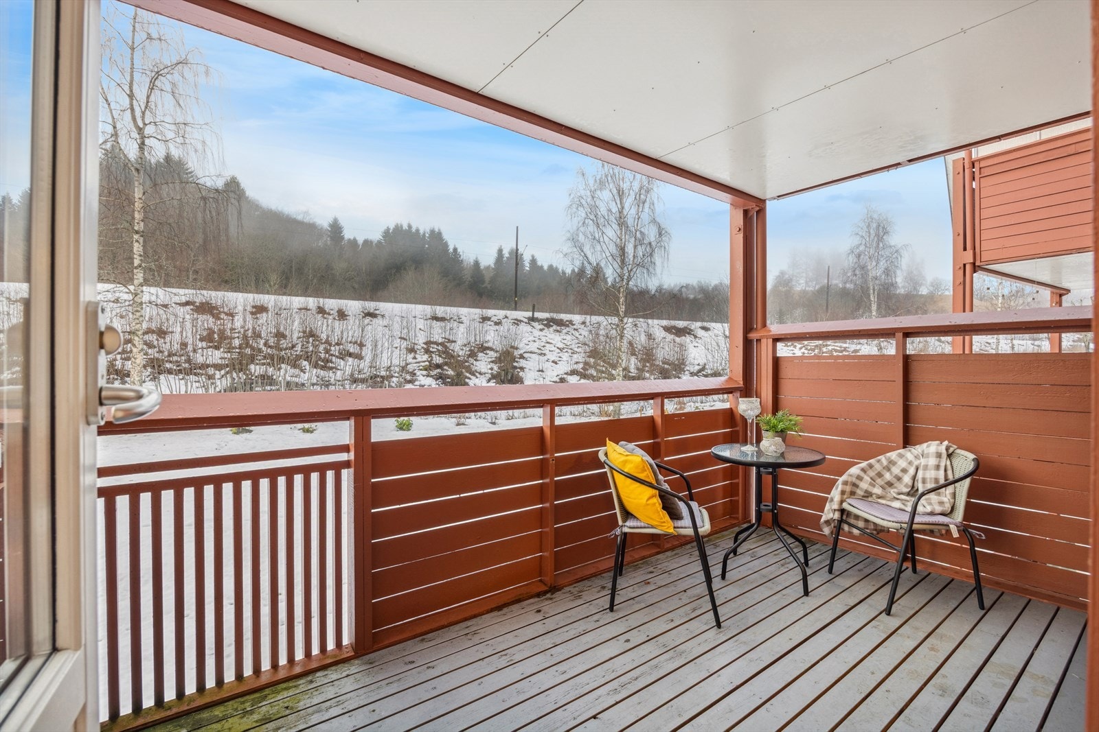 Overbygd balkong med utsikt mot grøntområde. Galleribilde