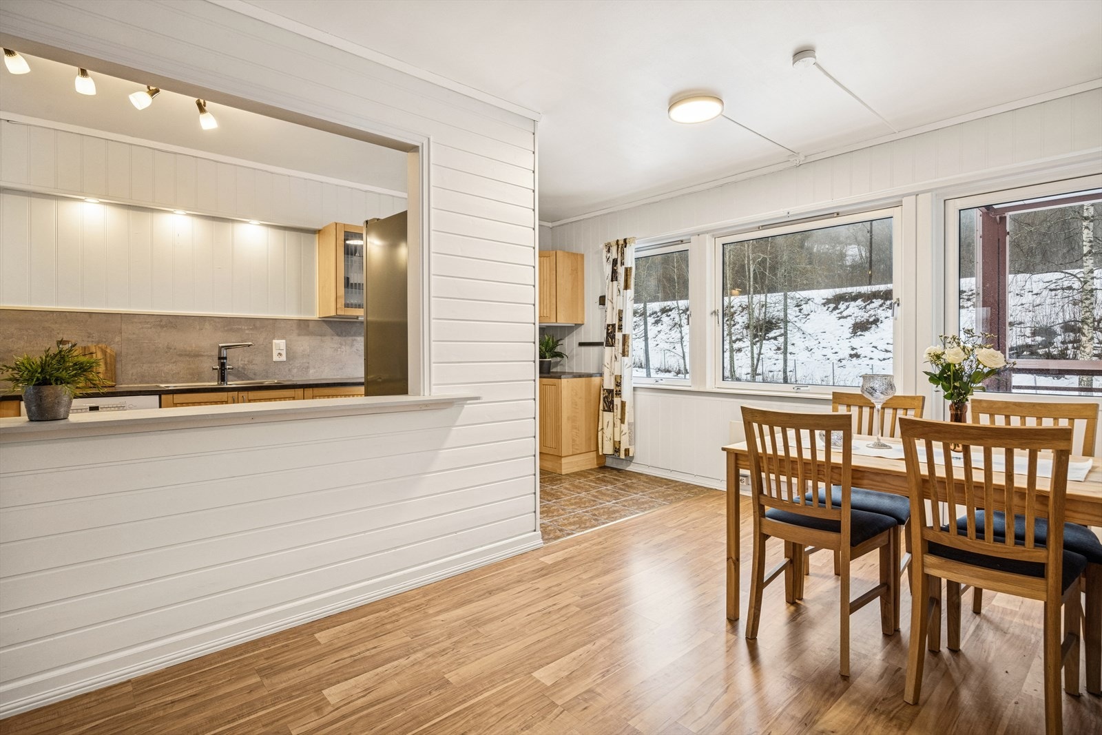 Store vinduer gir naturlig lys til spiseplassen og utsikt mot hageområde. Galleribilde