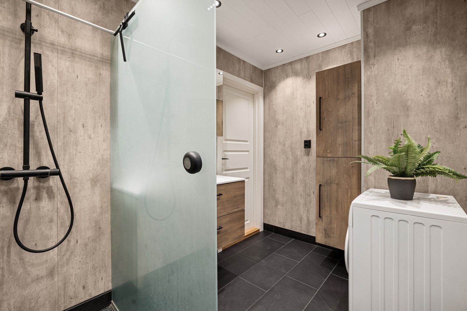 Panel i himling. Det er etablert plastsluk i dusjsonen. Det er synlig mansjett under klemring i sluk. Vannrør av plast (rør i rør), plastavløp. Galleribilde