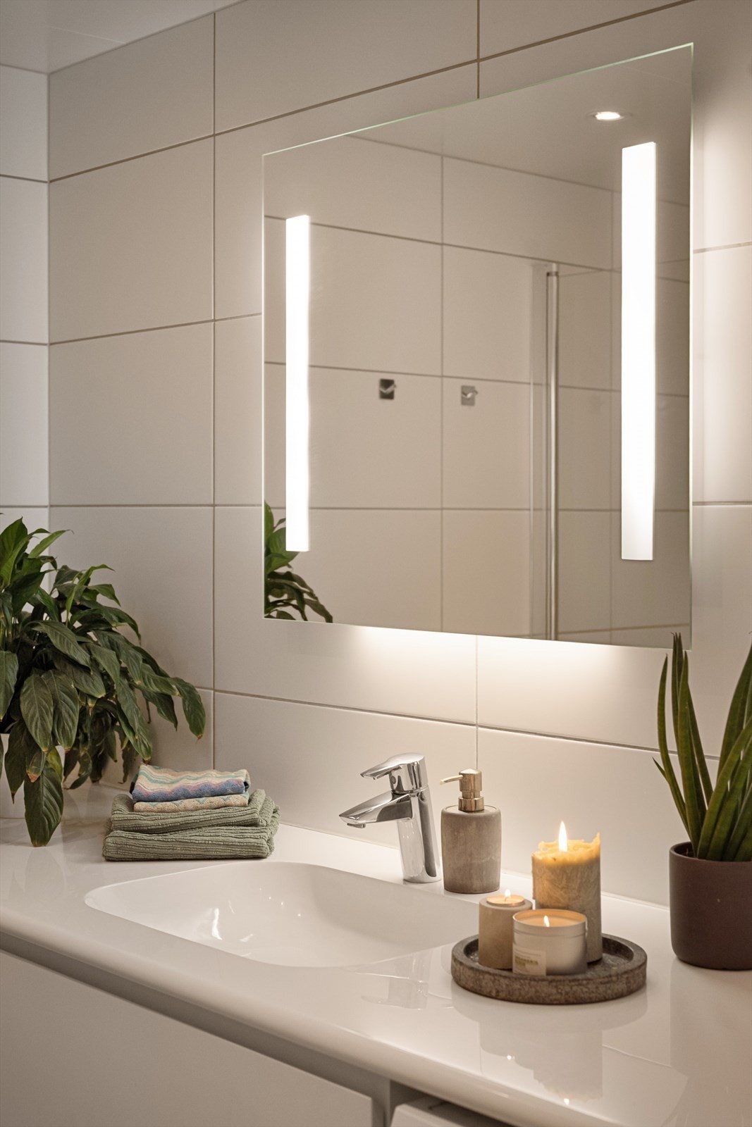 Badet er utstyrt med dusjhjørne, vegghengt toalett, servant med skuffer under og speilskap. Galleribilde