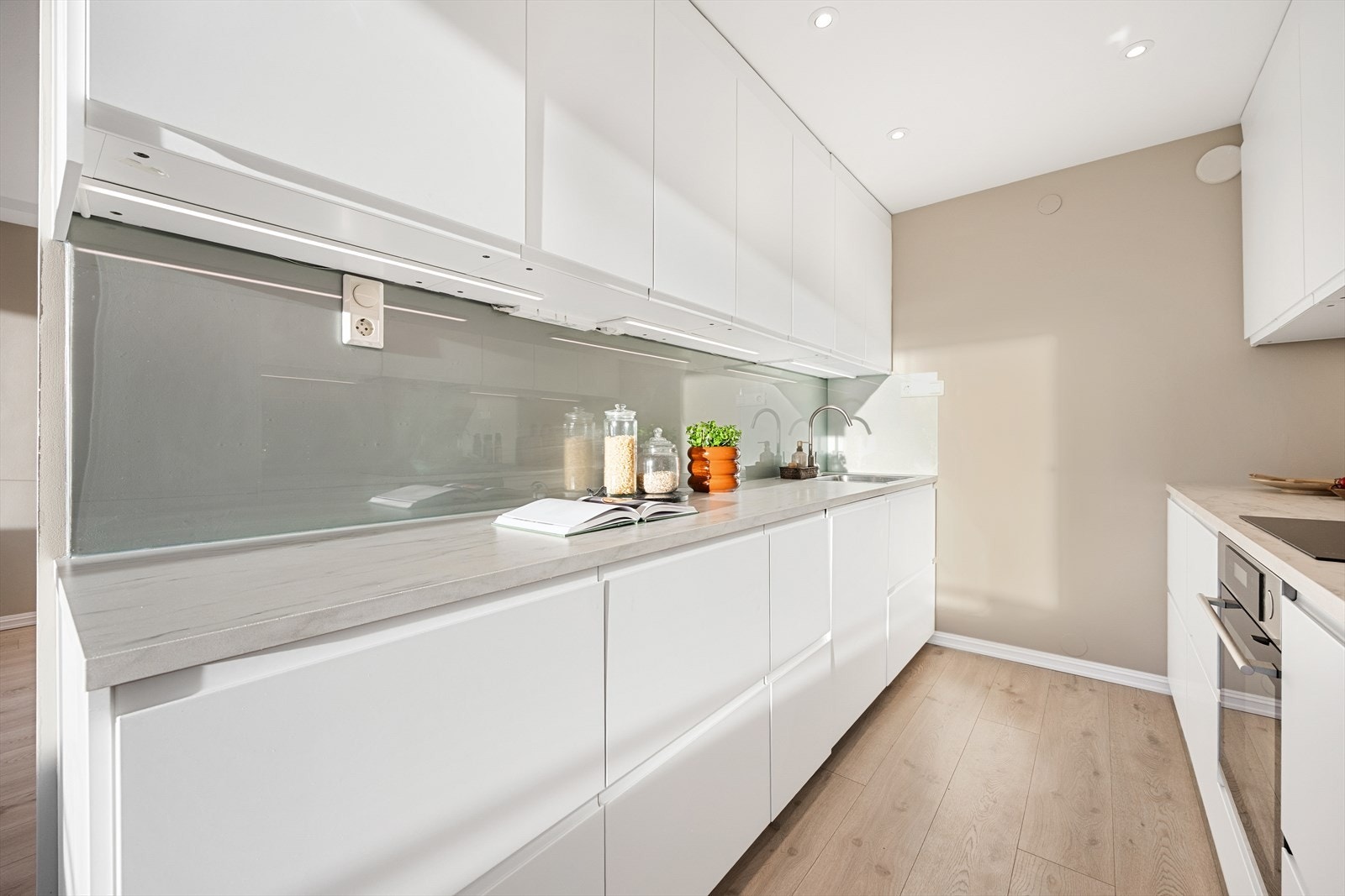 Integrerte hvitevarer inkluderer platetopp, stekeovn, oppvaskmaskin og kjøl-/fryseskap. Galleribilde