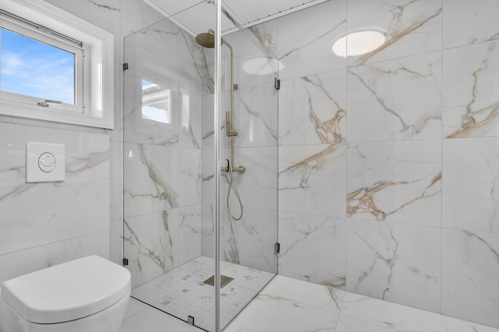 På badet er det blant annet dusjhjørne, vegghengt toalett og baderomsinnredning. Galleribilde