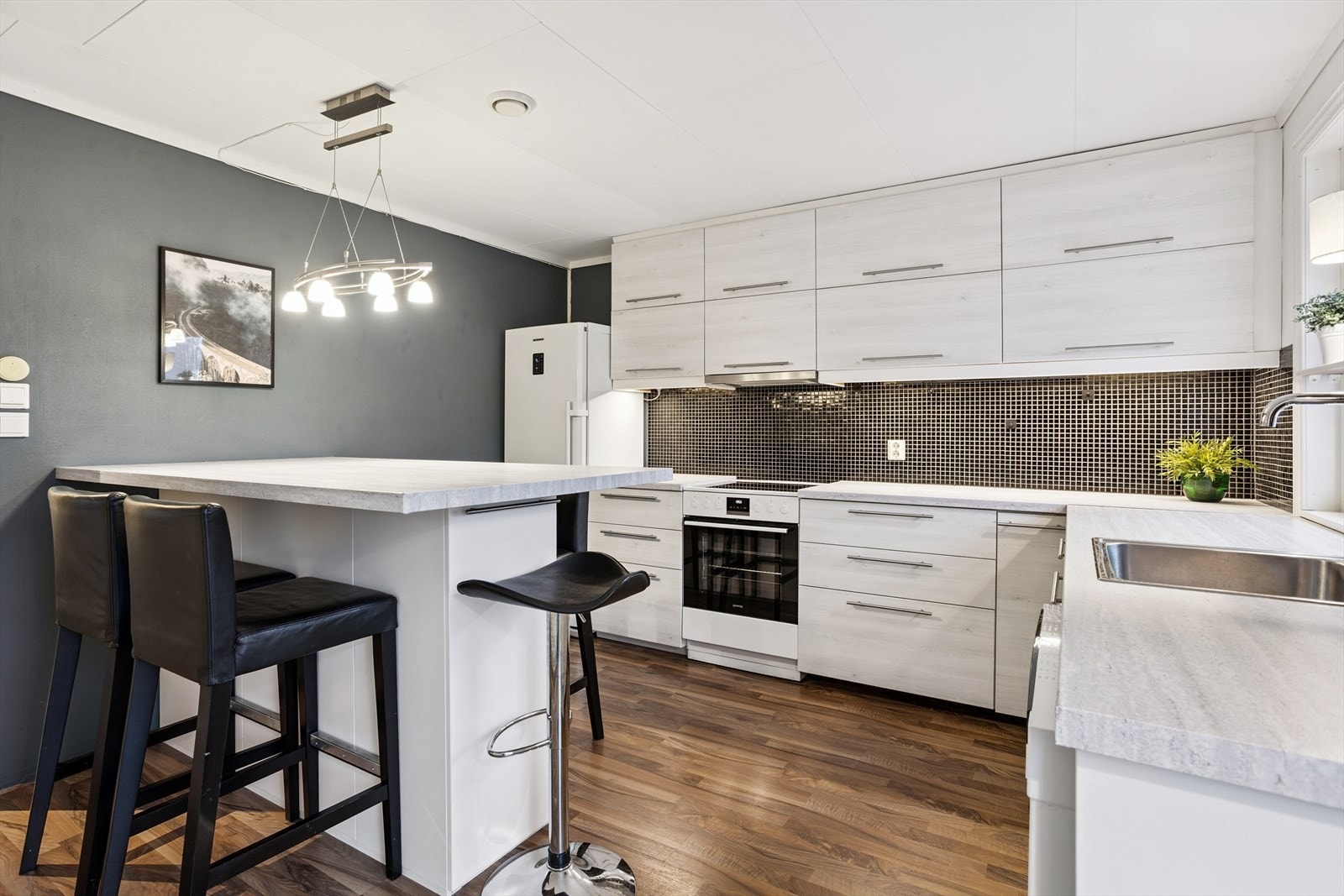 Kjøkkenet er et sosialt rom med naturlig samlingspunkt rundt øyen. Det er rikelig med oppbevaringsplass. Herfra er det også utgang til en terrasse. Galleribilde