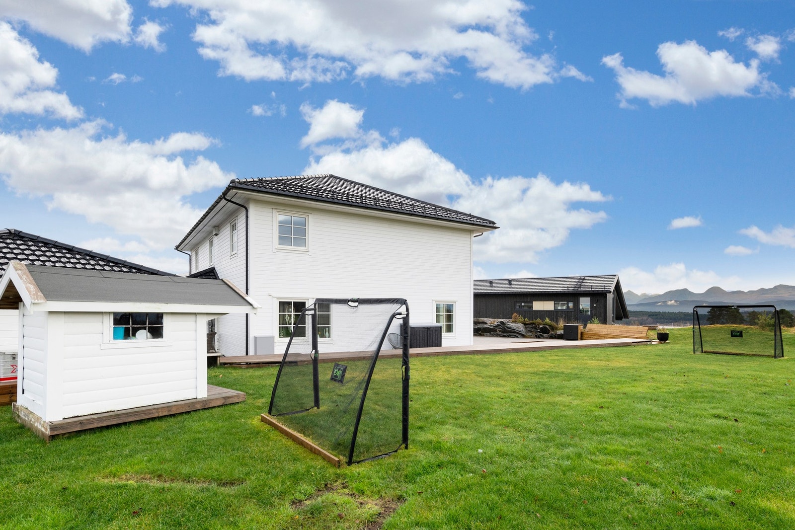 Uteområdet er brukervennlig med stor markterrasse og flat gressplen til lek og moro. Galleribilde