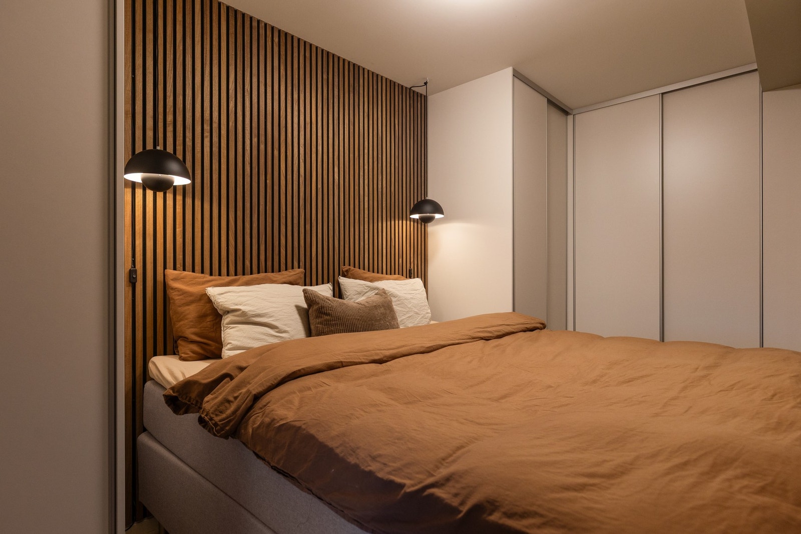 Tidsriktig spilevegg og stor skyvedørsgarderobe med rikelig plass til klær og sko. Galleribilde