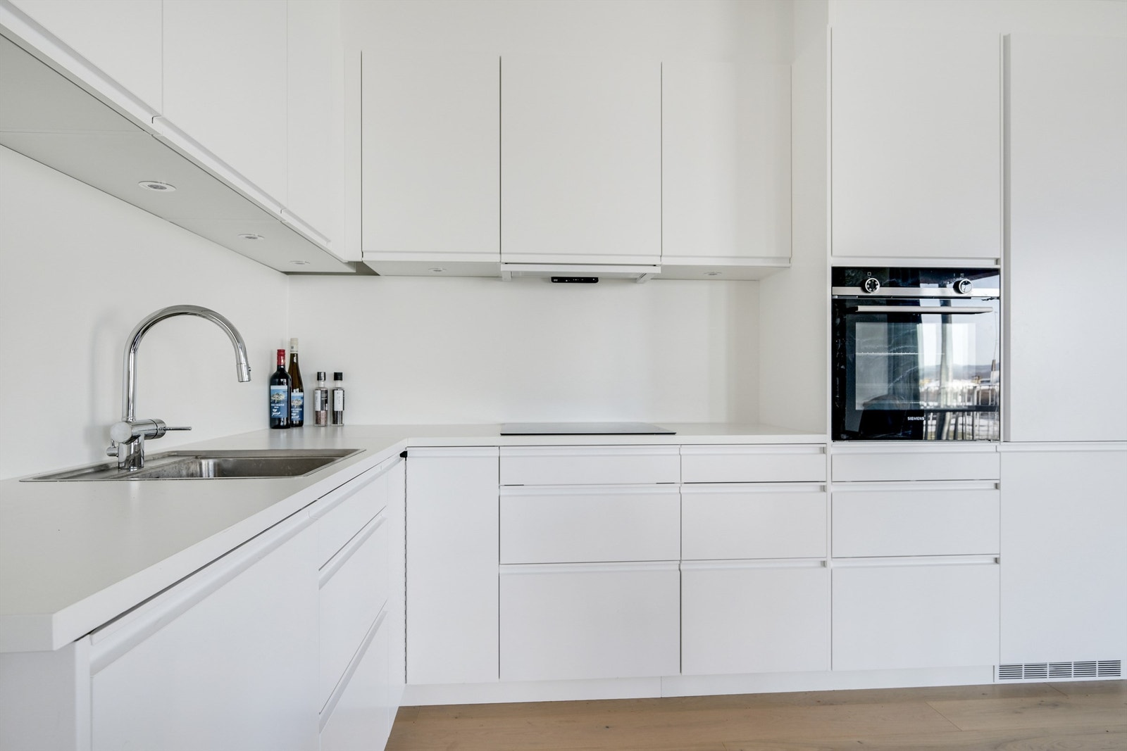 Pent kjøkken med integrerte hvitevarer og godt med skapplass Galleribilde