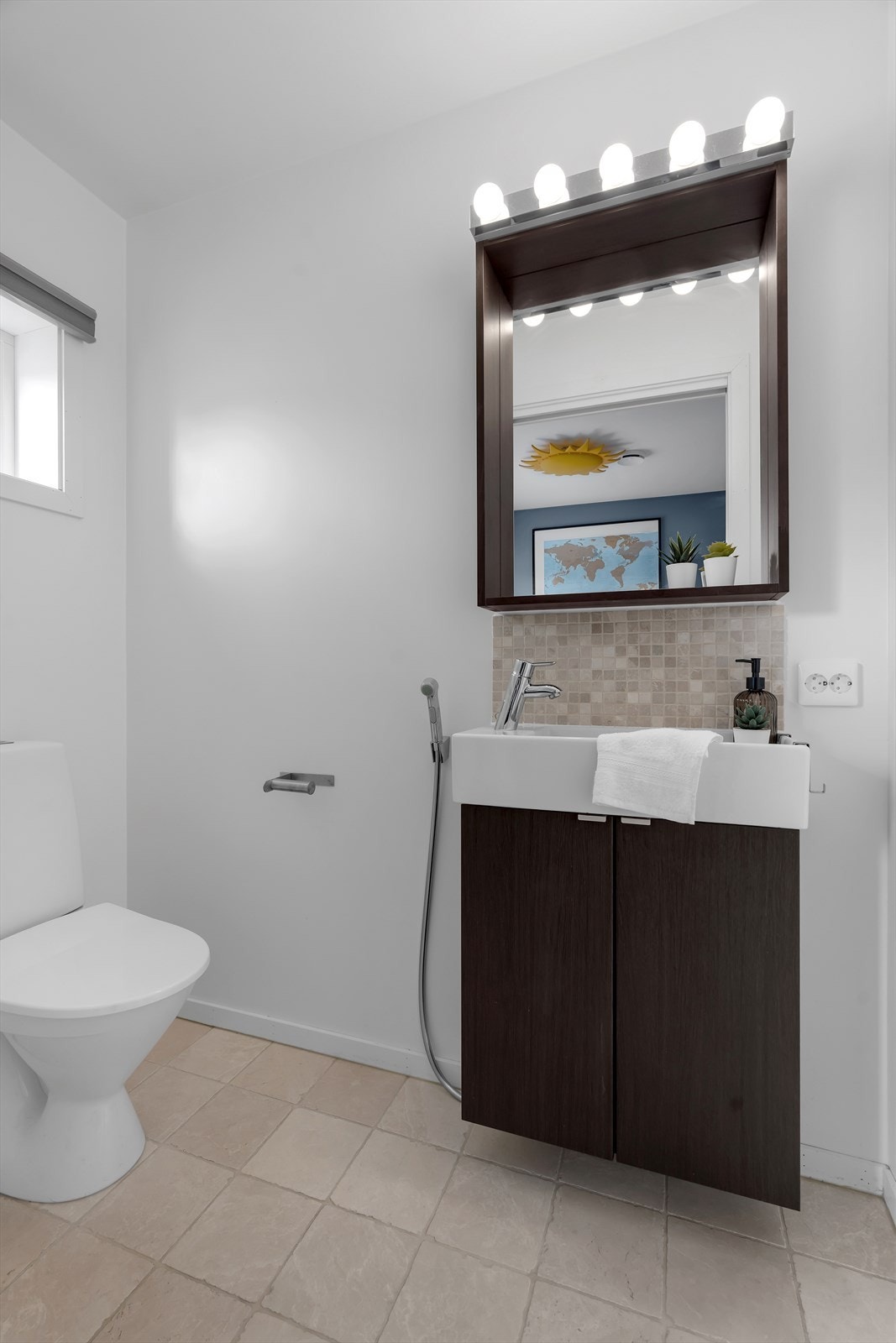 I tillegg har boligen et praktisk toalettrom med fliser på gulv og moderne sort innredning som inkluderer servant, speil og toalett. Galleribilde