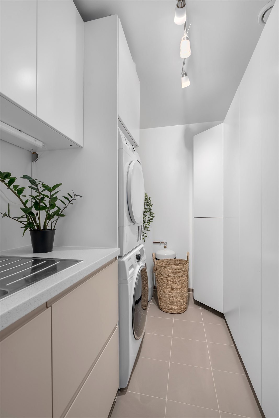 Vaskerommet er delikat innredet med lyst interiør, inkludert vask og skapplass, samt veggmonterte skap for oppbevaring. Galleribilde