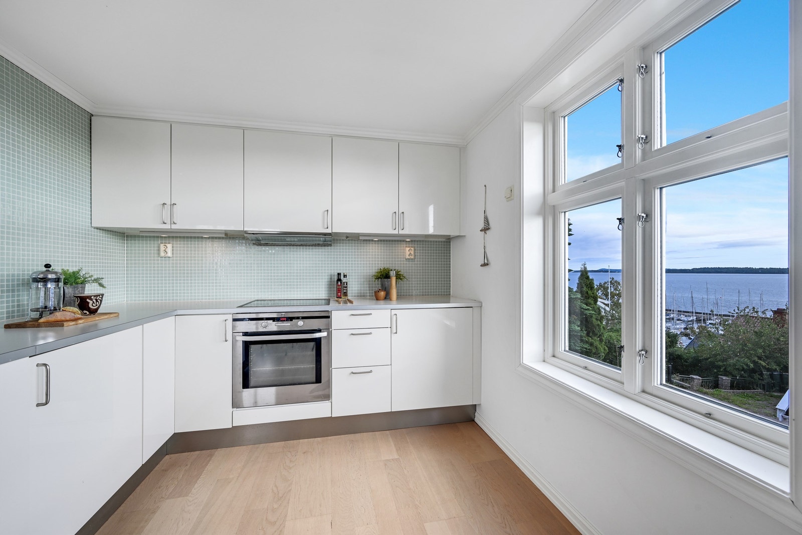 Kjøkken med mosaikkfliser på vegg og over benker. Galleribilde