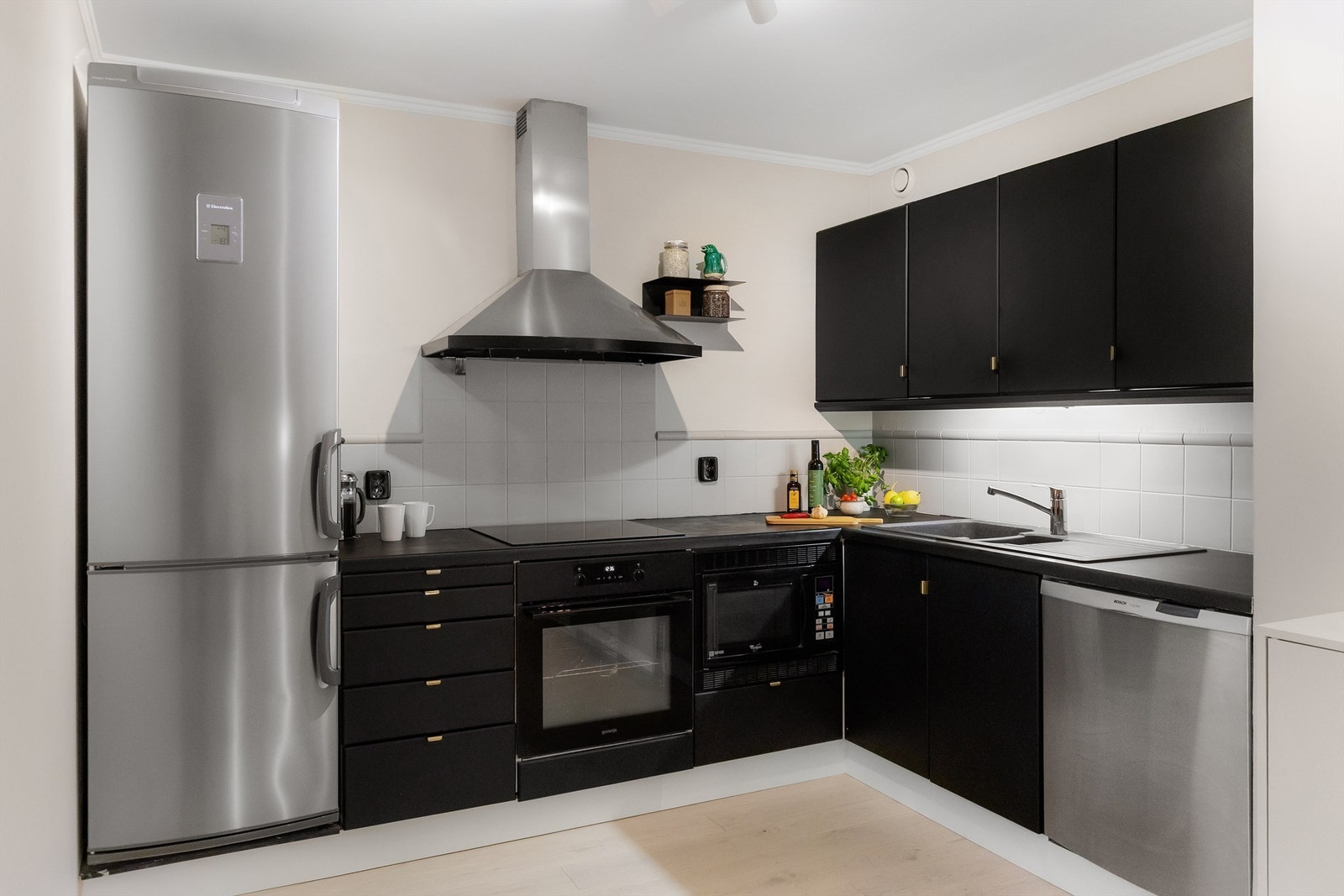 Kjøkkenet har glatte fronter på skap og skuffer og laminert benkeplate Galleribilde