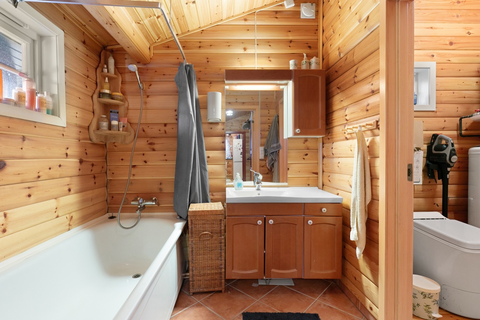 Badet har flislagt gulv med gulvvarme og panel på vegger. Galleribilde