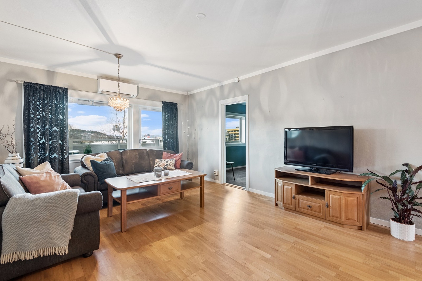 De store vindusflatene gir mye naturlig lysinnslipp. Her kan du nyte utsikten fra sofakroken. Enkel adkomst til privat veranda fra stue. Galleribilde