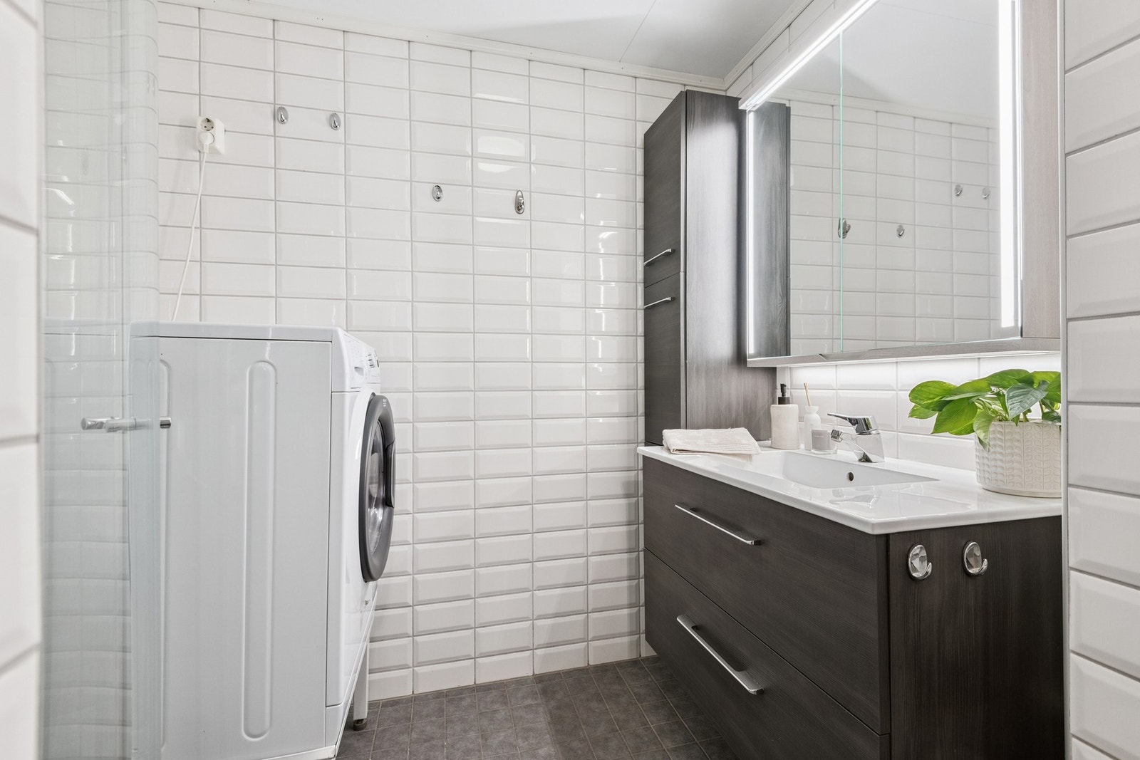 Badet har en romslig innredning, dusjhjørne og opplegg for vaskemaskin. Galleribilde