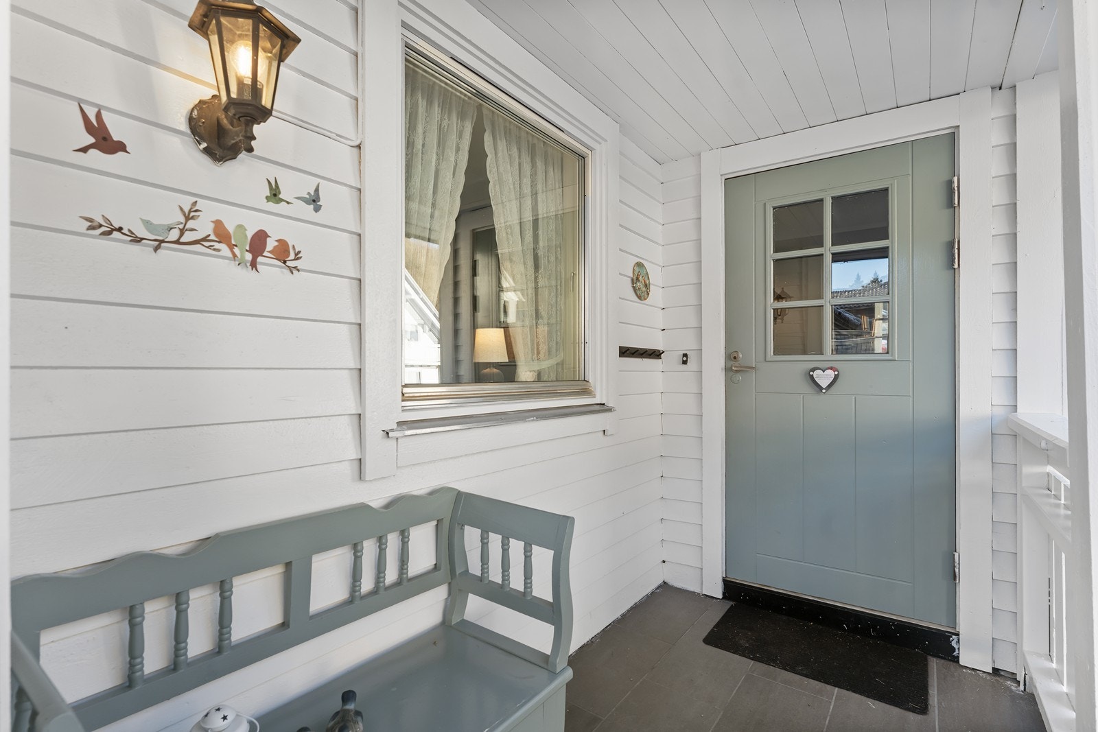 Inngangspartiet er lunt og koselig, flislagt med overbygg. Her er det enkelt å møblere med benk eller dekorere med vakre blomster Galleribilde