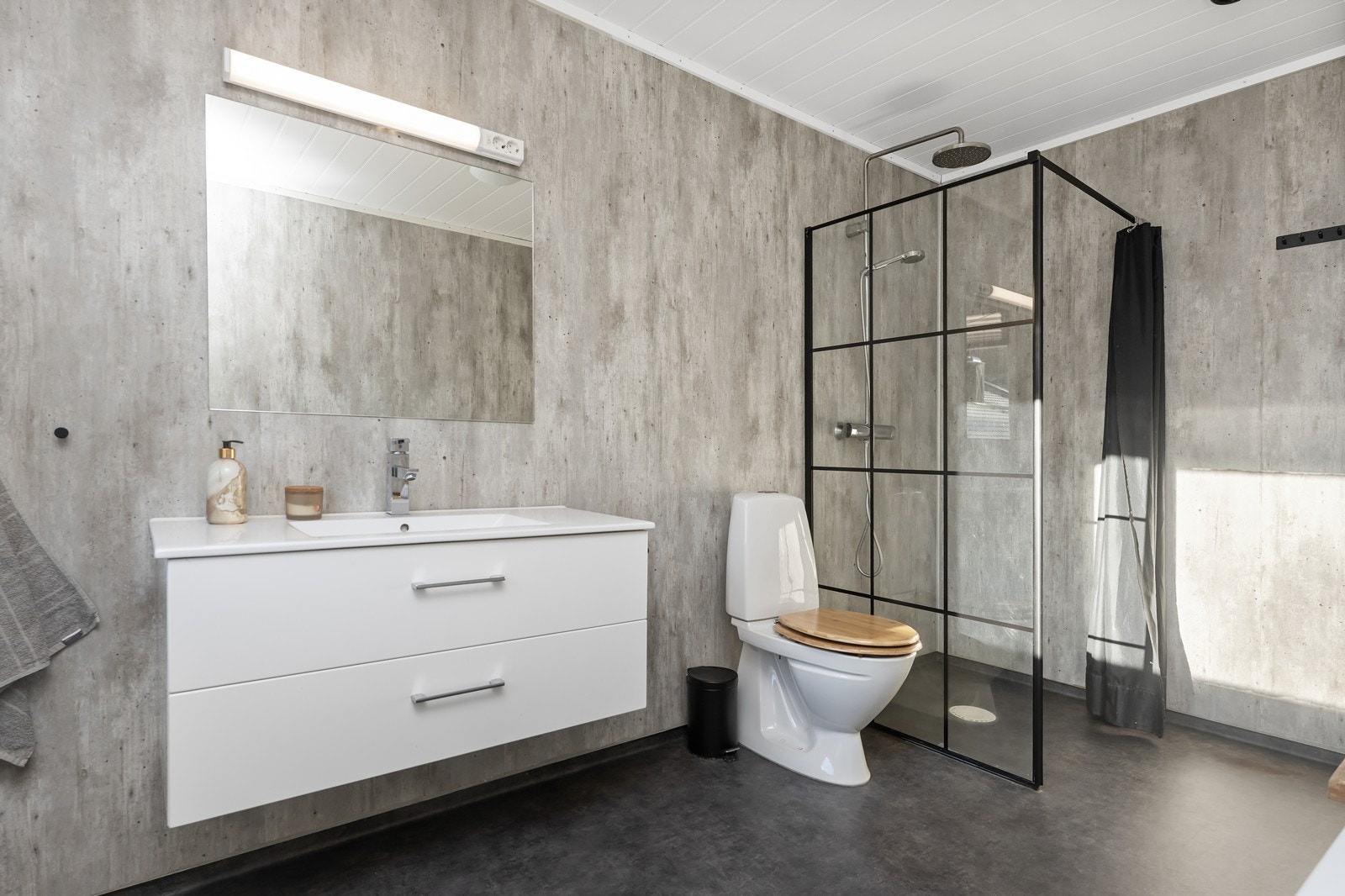 Rommet har dusjhjørne, badekar, toalett og innredning med nedfelt servant. Galleribilde