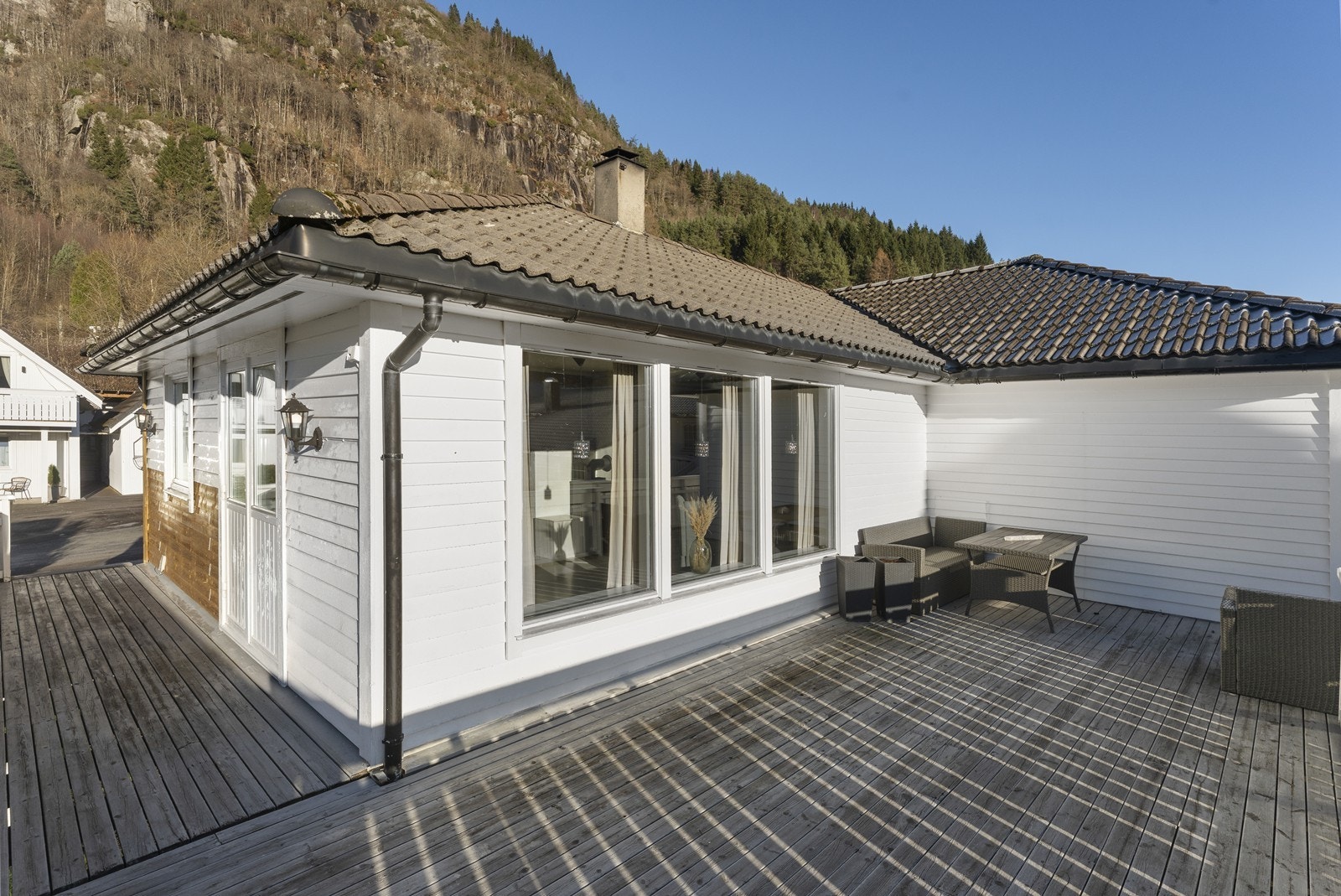 Terrassen er på hele 46 kvm og strekker seg på to sider av boligen som gjør at man enkelt kan flytte seg utfra sola. Galleribilde