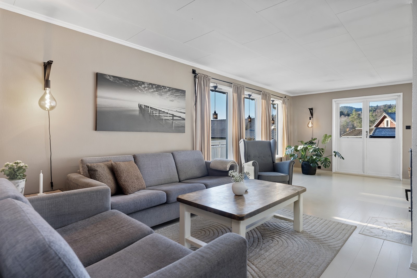 Stuen er malt i lune og moderne farger med lyst gulv og beige vegger. Galleribilde