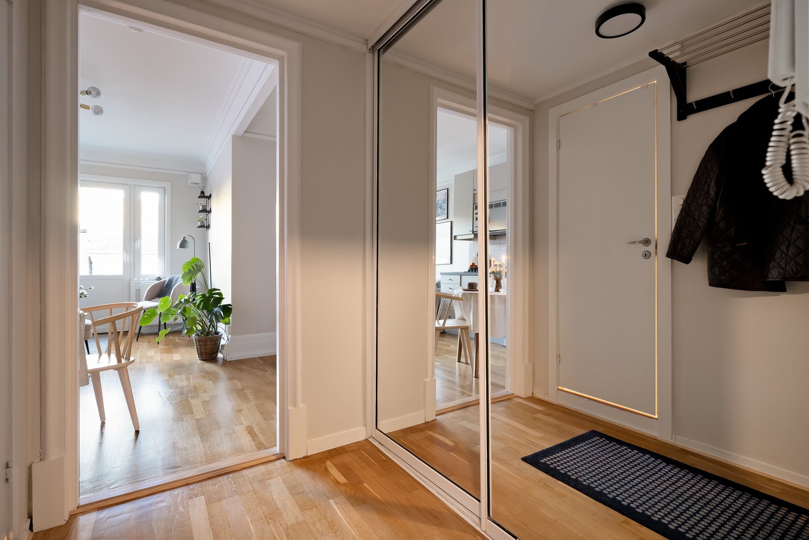 Velkommen inn til en romslig entré med mye lagringsplass i skyvedørsgarderobe med speildører. Galleribilde