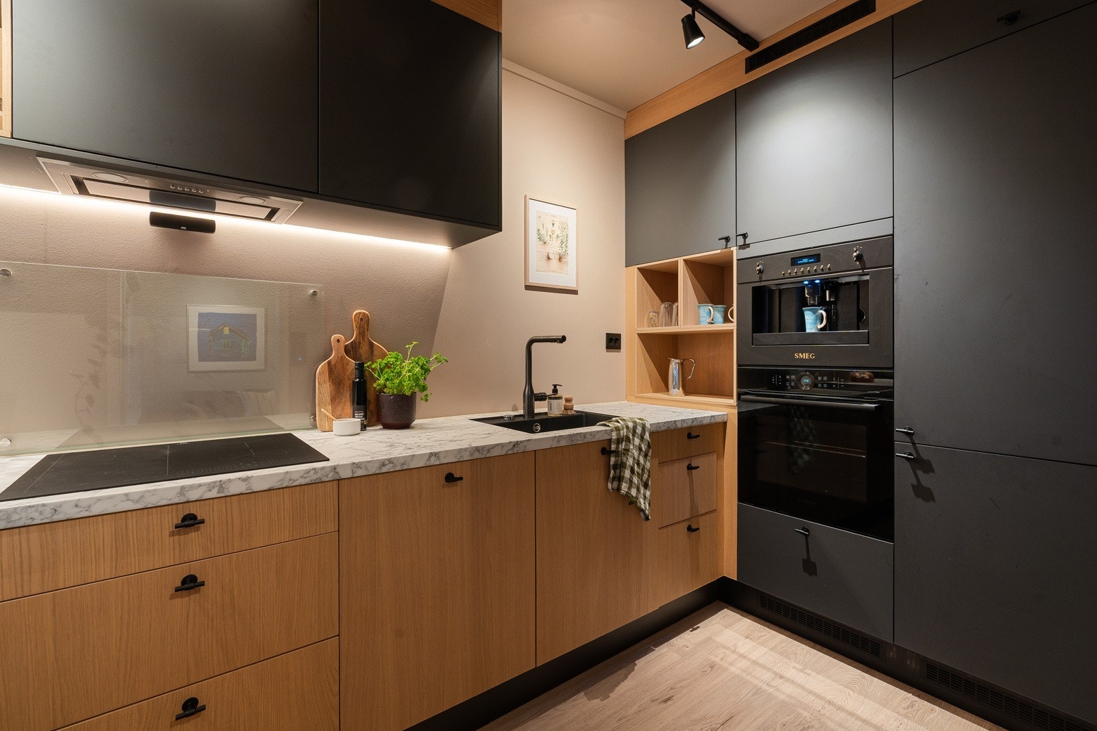 Kjøkkenet er utstyrt med integrerte hvitevarer som kjøl/fryseskap, kaffemaskin, oppvaskmaskin med vannstoppsystem, induksjonstopp med komfyrvakt og stekeovn. Galleribilde