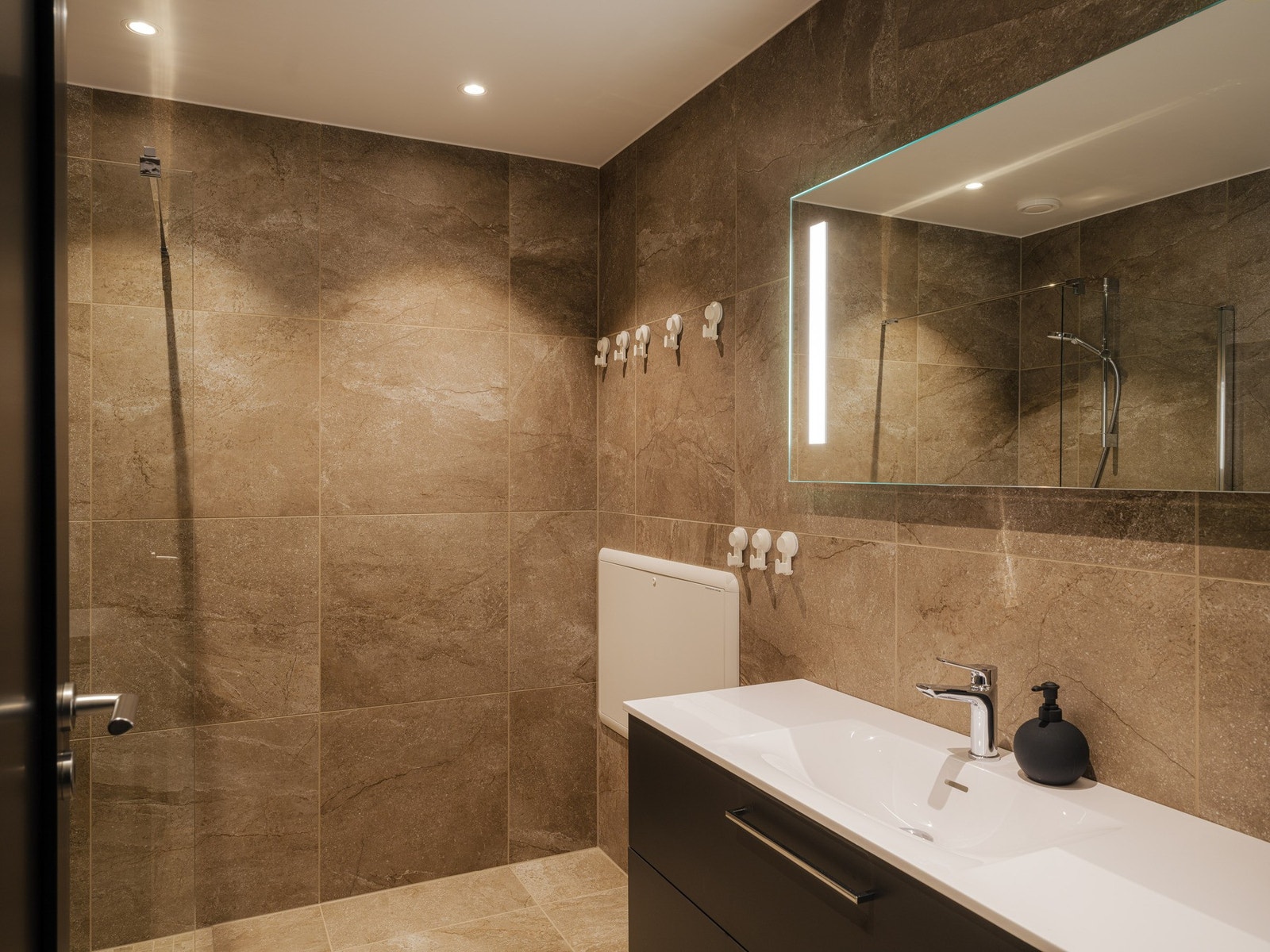 Leiligheten har også to bad. Badet er flislagt med elektriske varmekabler i gulv som fjernstyres via app. Galleribilde