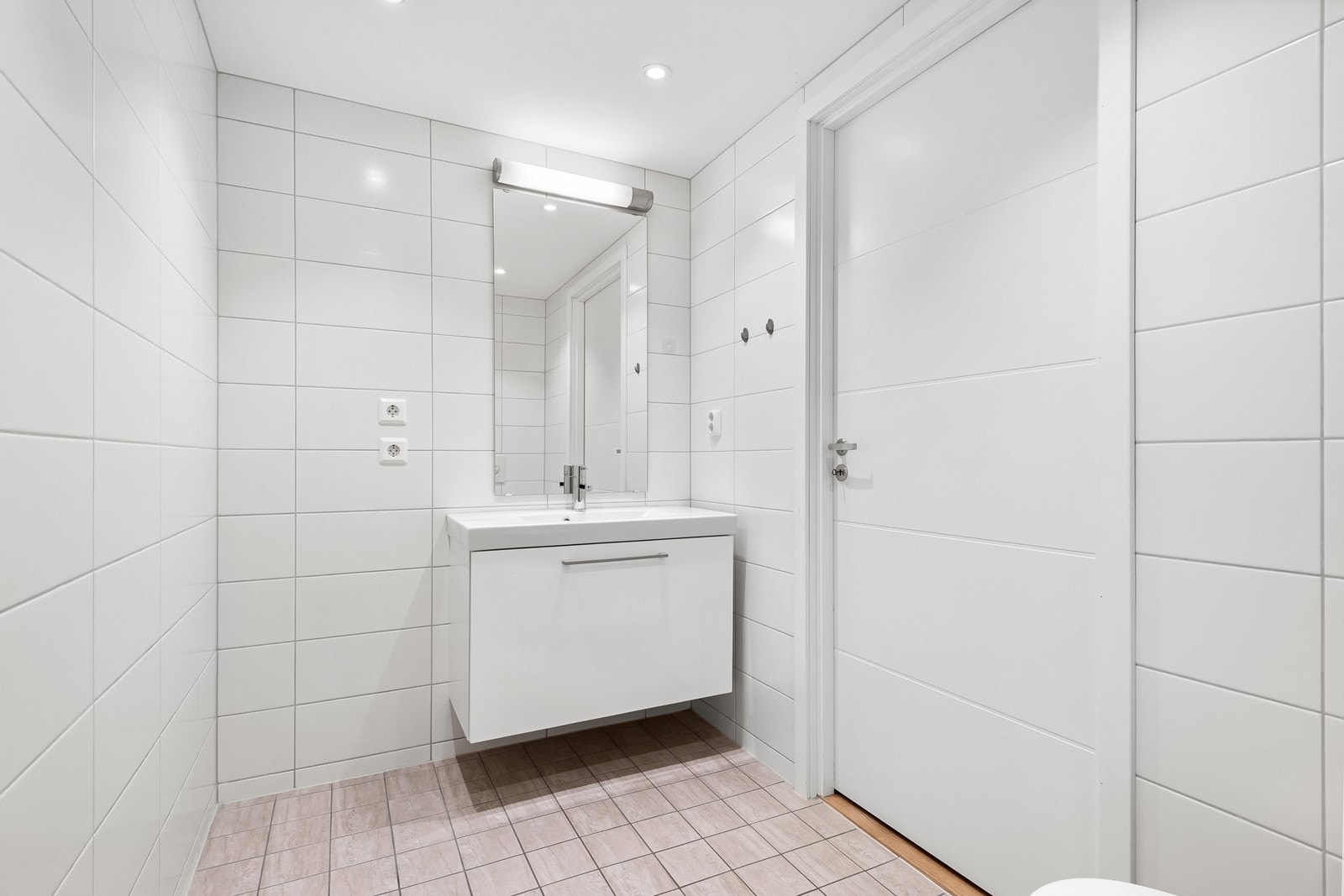 Flislagt baderom fra 2017 med lyse flater, gulvvarme og downlights. Galleribilde