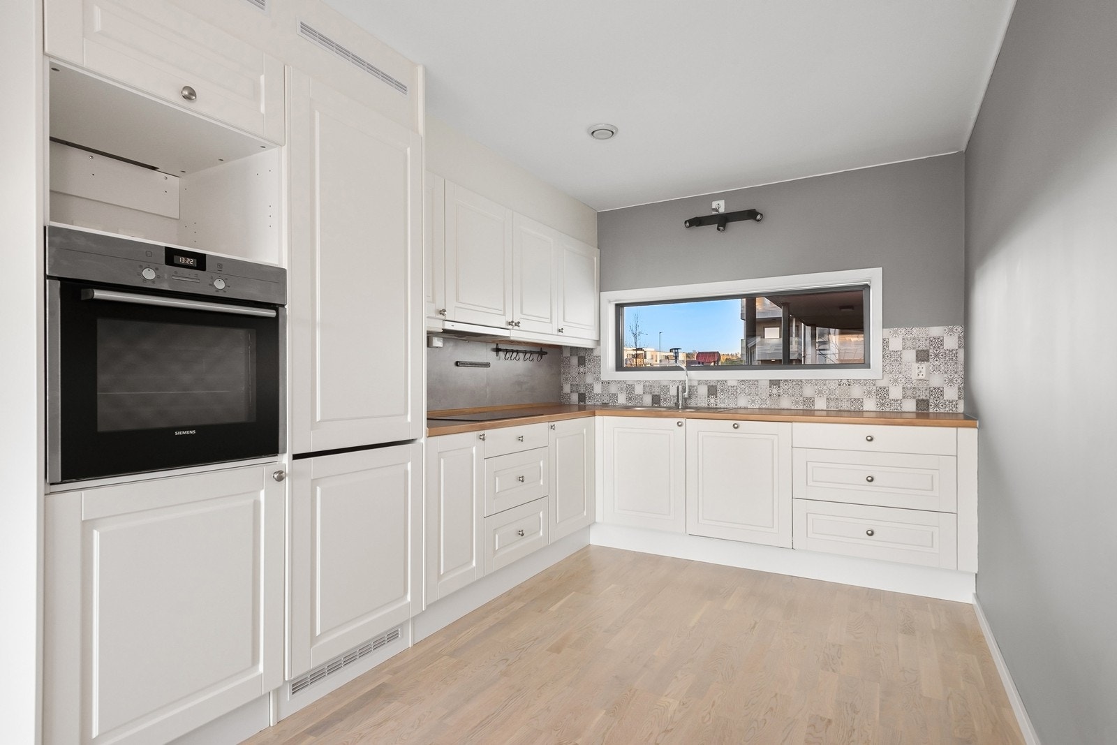 Kjøkkenet har rikelig med skap- og benkeplass og er utstyrt med integrert oppvaskmaskin, platetopp og stekeovn. Galleribilde