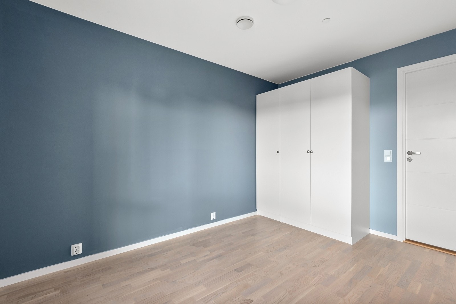 Hovedsoverommet er malt i en lun blåtone og har god plass til garderobeløsning langs veggen. Galleribilde