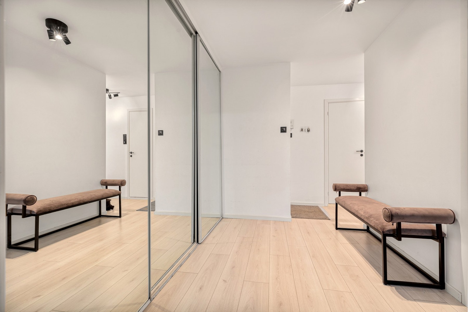 Hall er innredet med en stor skyvedørsgarderobe Galleribilde