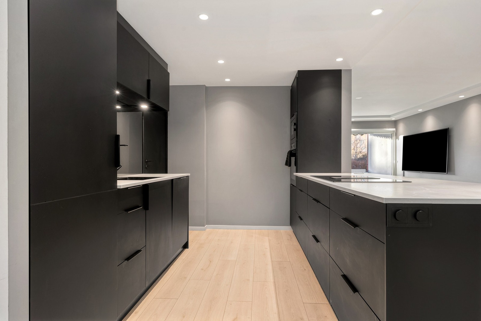 Stilrent kjøkken med integrerte hvitevarer og god benkeplass Galleribilde