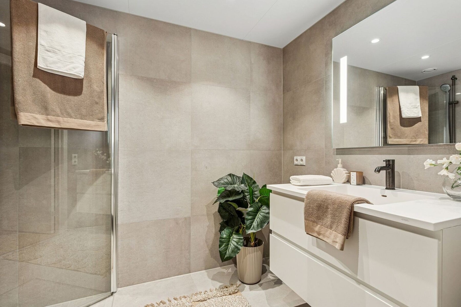 Gjestebad er på 4,2 kvm og har opplegg til vaskemaskin. Leiligheten har to delikate baderom. Galleribilde