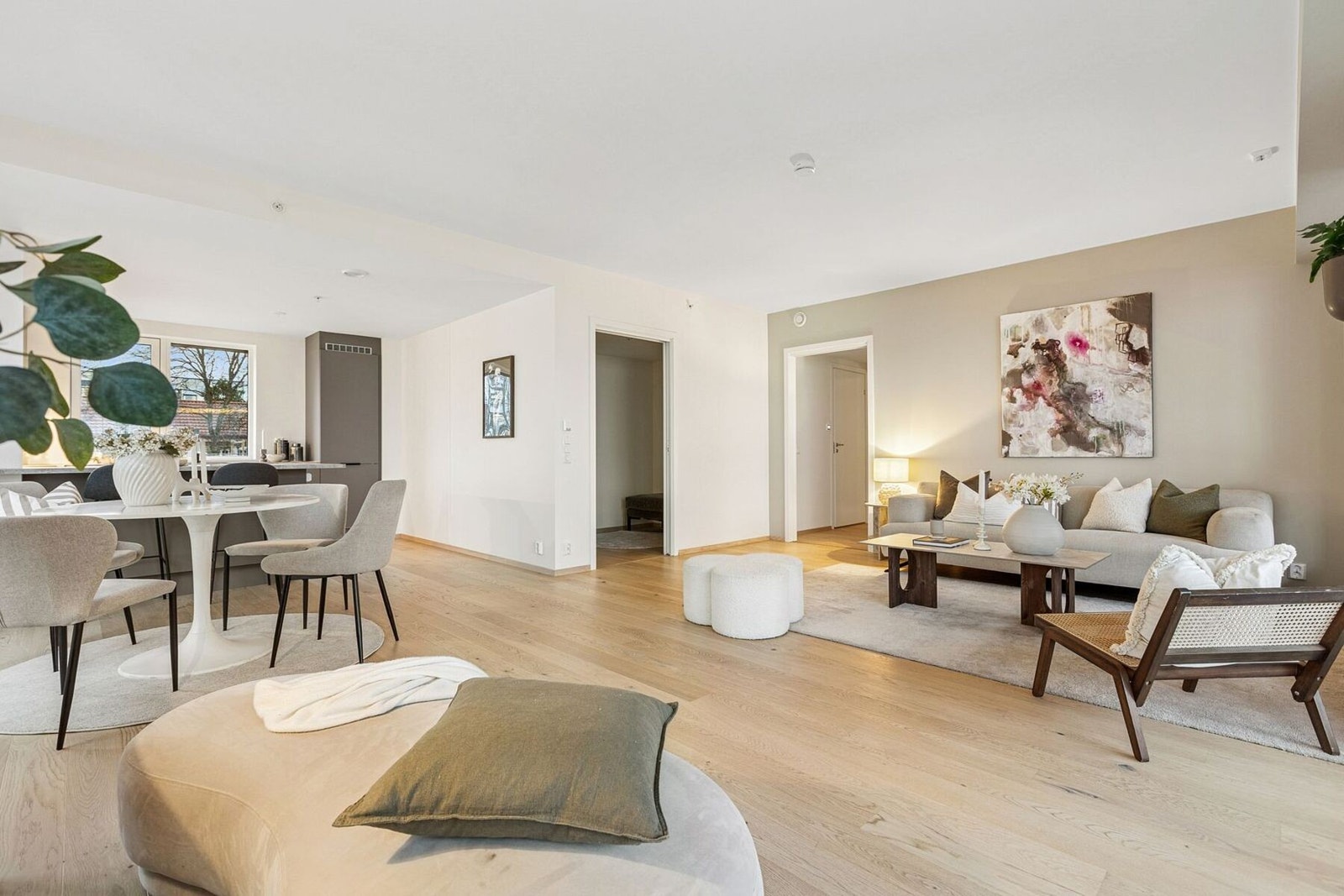 Romslig stue-/kjøkkenløsning med plass til en stor sittegruppe, samt spiseseksjon i forbindelse med kjøkkenet. Galleribilde