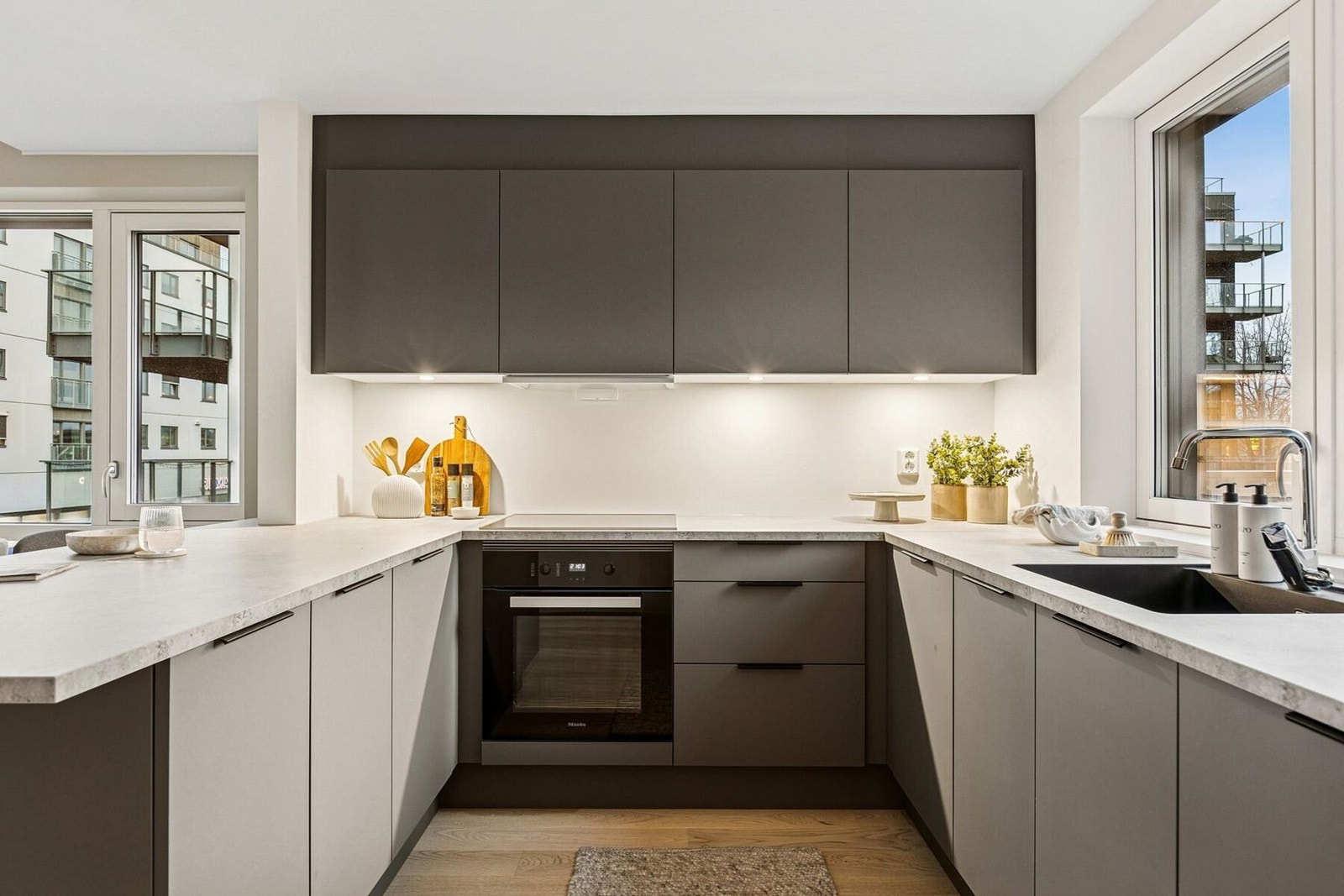 Stort hjørnekjøkken med integrerte hvitevarer, samt mye skap- og benkeplass. Praktisk kjøkkenøy med bar-løsning. Galleribilde