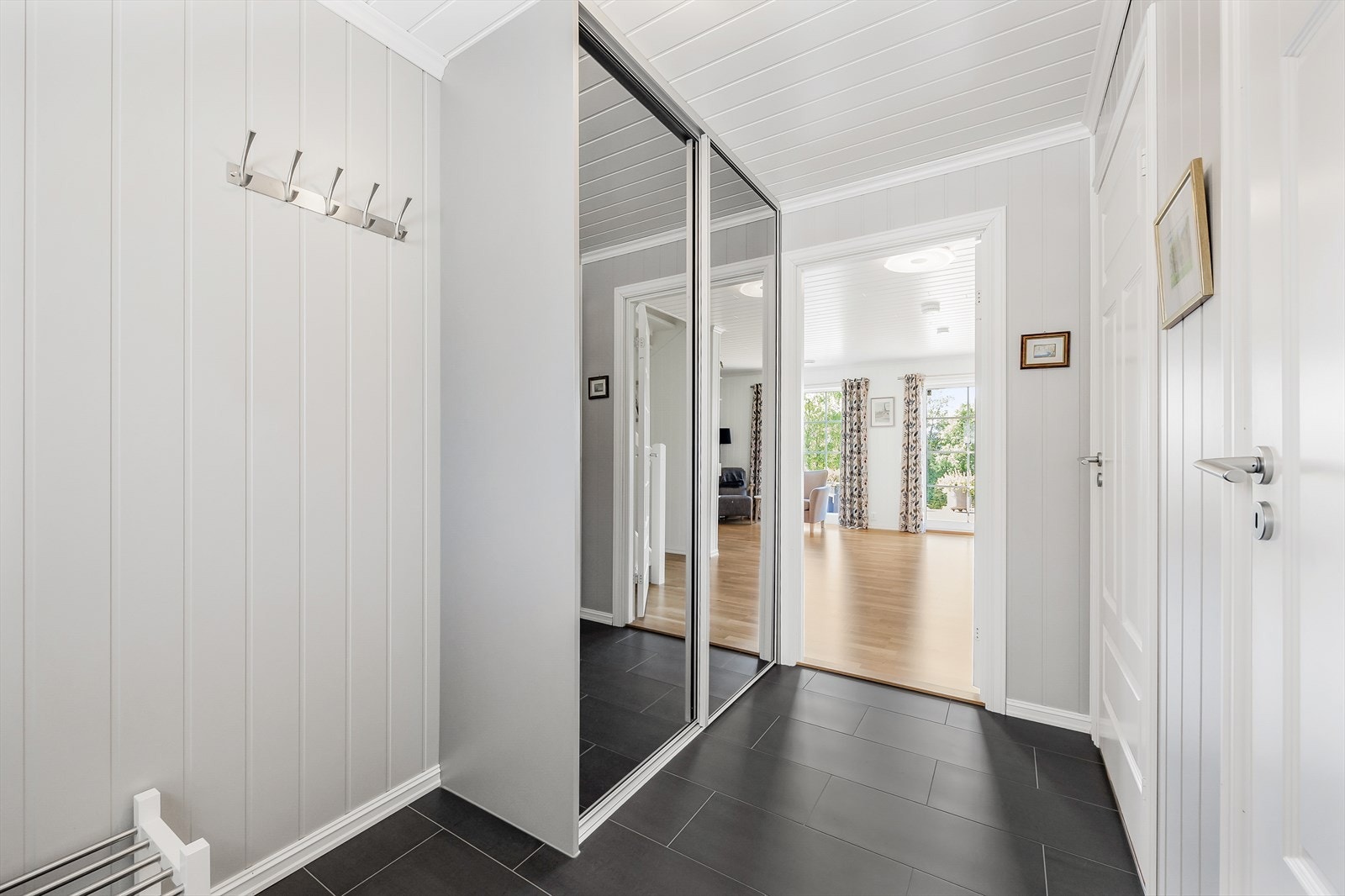 Flislagt gulv i gangen med stor skyvedørsgarderobe - stilfullt og funksjonelt. Det er gulvvarme i hele 1. etasje. Galleribilde