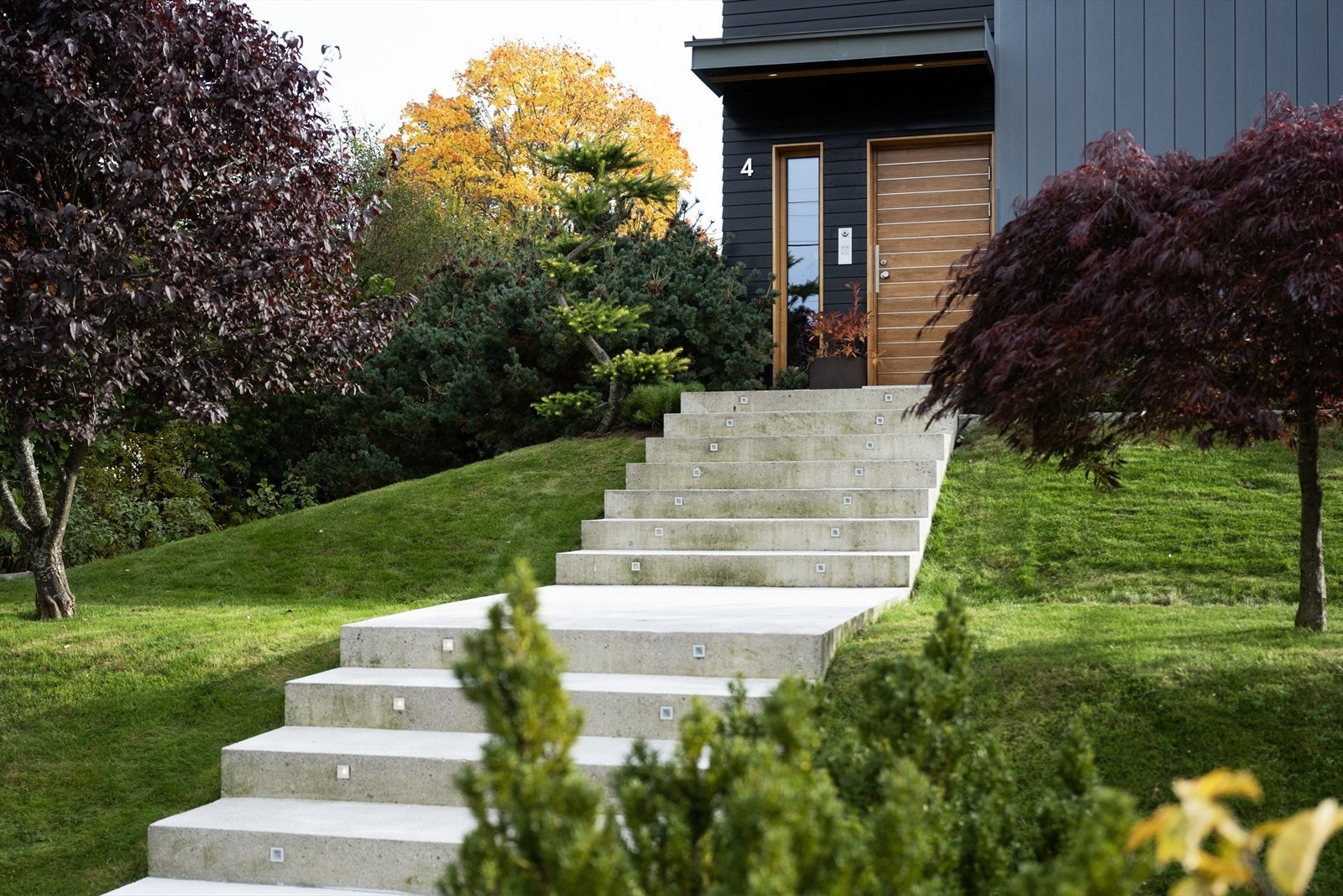 Eiendommen er eksklusivt opparbeidet med grønne plener, vakker beplantning og en gjennomført hageutforming. Det er etablert en eksklusiv trapp i betong med varmekabler og integrert belysning fra gaten opp til inngangspartiet. Galleribilde