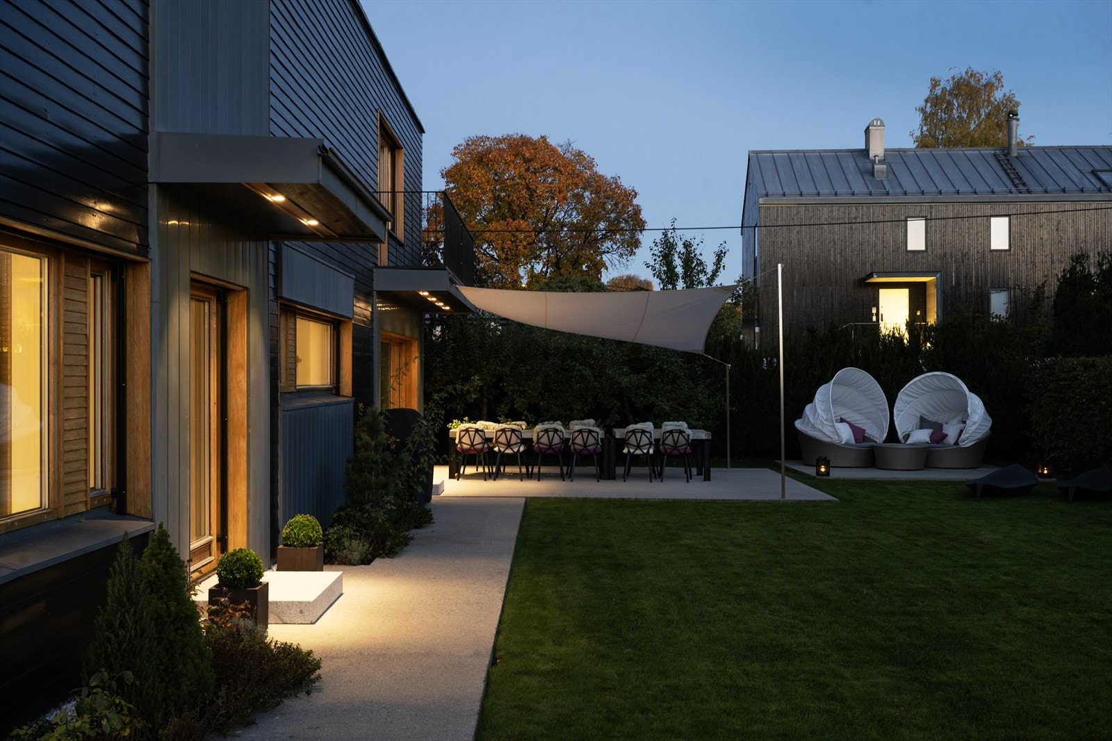 Fantastisk uteområde med terrasser av slipt betong, vakker beplantning og spisestue under seilduk. Fantastisk beplantning med blant annet busker av Rhododendron, Magnolia, Syriner, Japansk viftelønn, Blodplomme, "Bonsai-lerk". Galleribilde