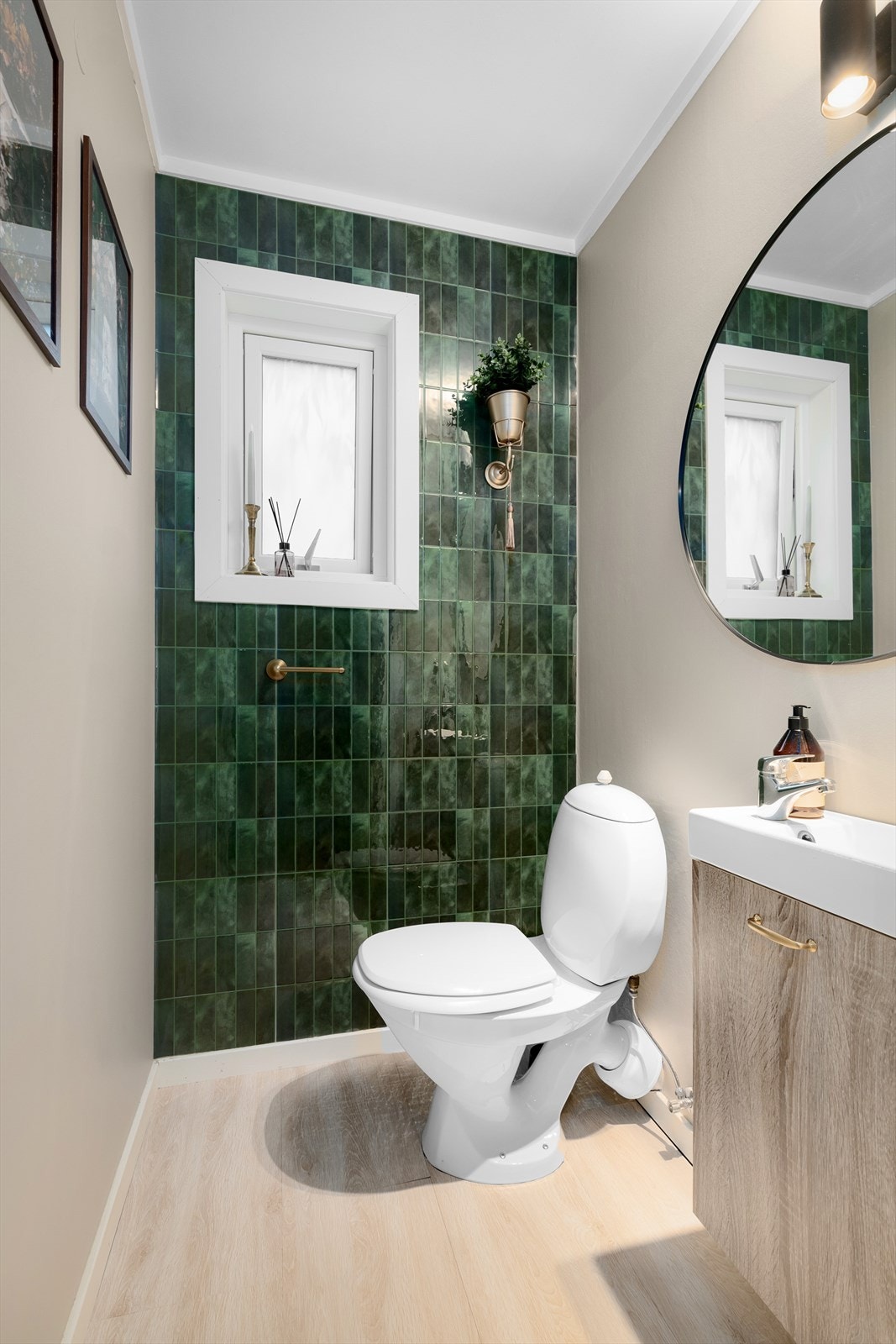 Toalettrommet har vegghengt servantskap med speil og belysning, samt gulvstående toalett. Veggene er av sparklet og malt gips med vinyltapet. Galleribilde