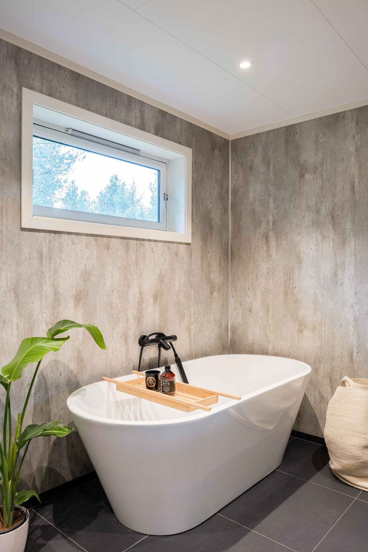 Badet er innredet med dusjvegger i glass, vegghengt toalett, dobbelservant med underskap, speil med lys, samt et luksuriøst badekar. Galleribilde