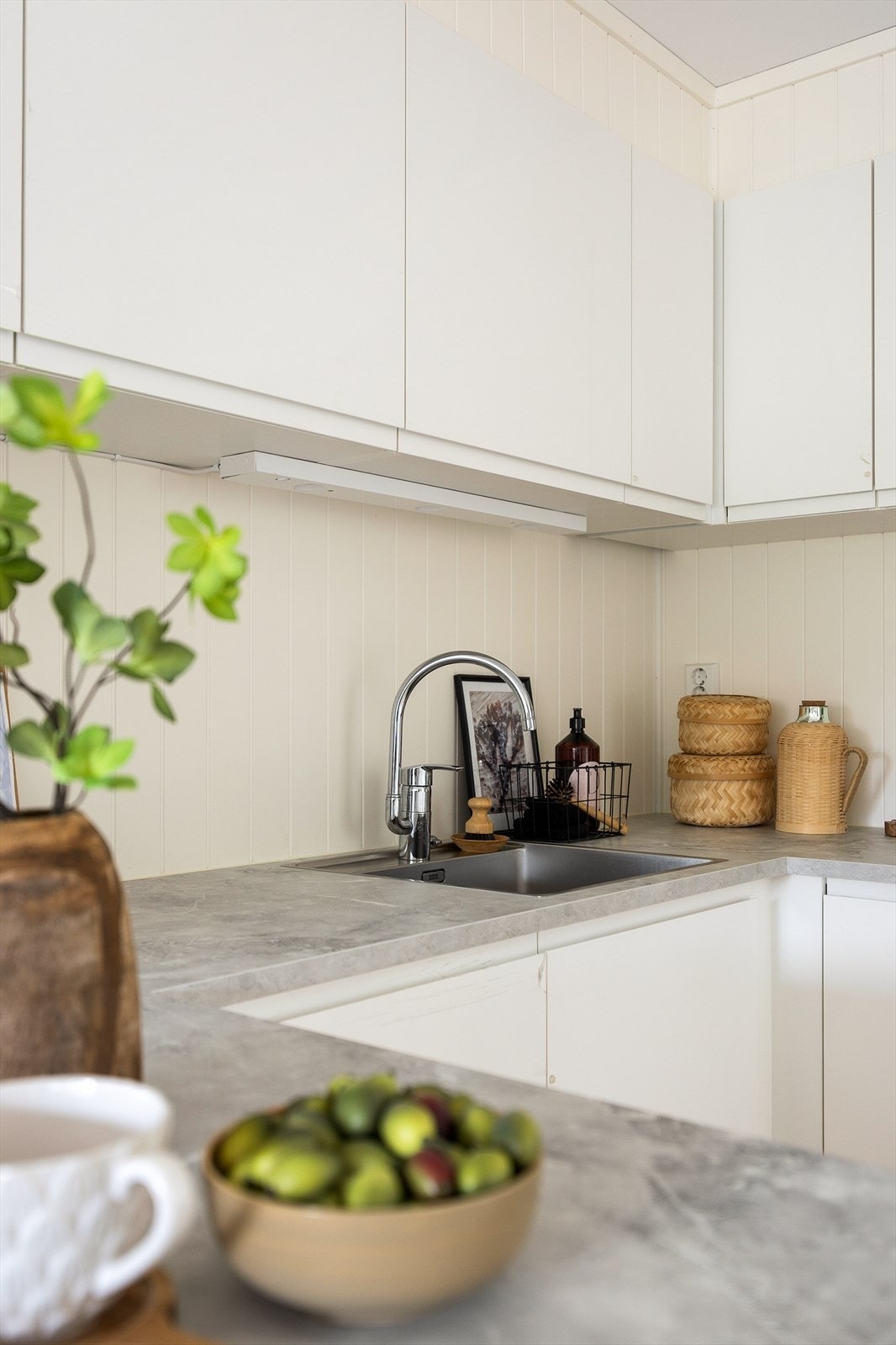 Detaljer som oppvaskkum i rustfritt stål og ettgreps blandebatteri understreker den moderne standarden. Galleribilde