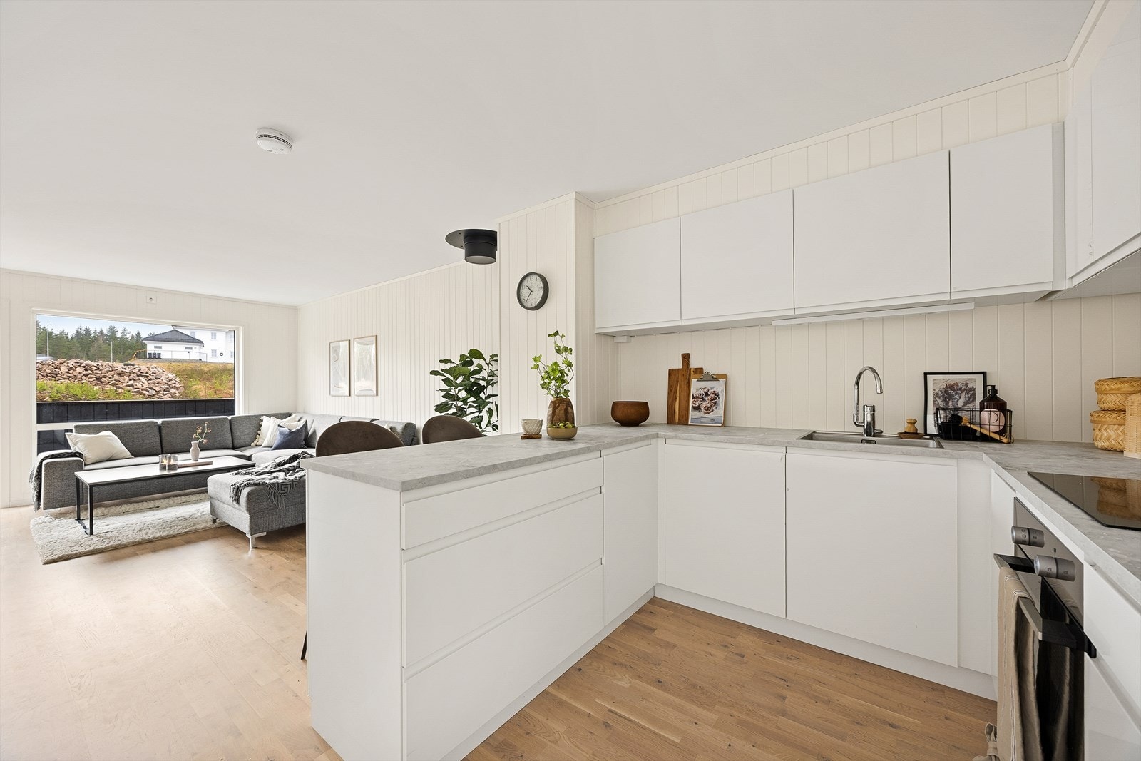 Gjennomgående parkettgulv og lyse panelplater på veggene skaper en helhetlig stil. Galleribilde